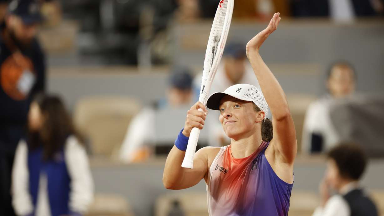 Poland's Iga Swiatek celebrates as she won her first round match against France's Leolia Jeanjean at the French Open tennis tournament, at the Roland Garros stadium in Paris, Monday, May 27, 2024.