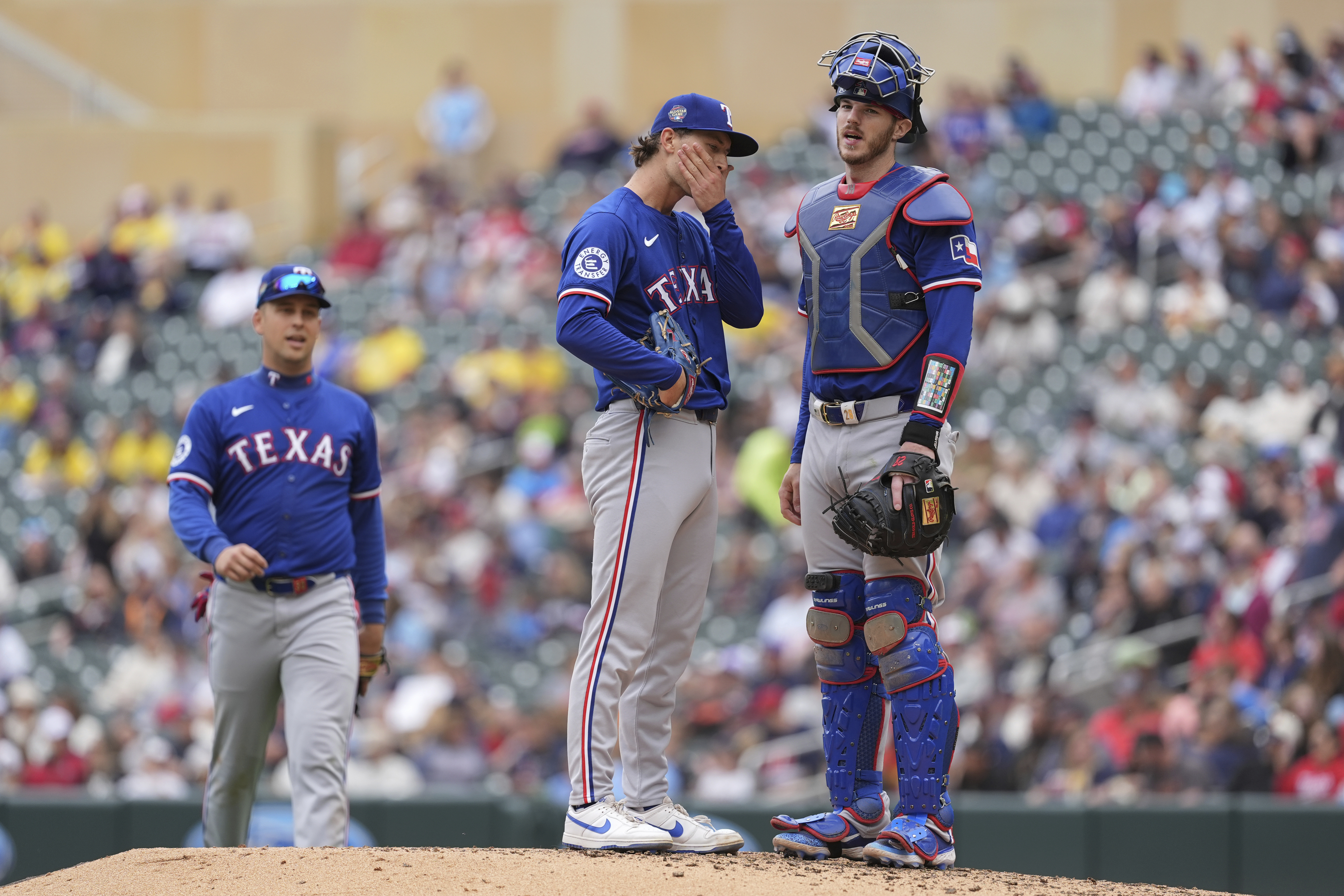 Texas Rangers reliever Jacob Latz, center, waits as manager Bruce Bochy (not shown) comes to make a pitching change during the seventh inning of a baseball game against the Minnesota Twins, Sunday, May 26, 2024, in Minneapolis. 