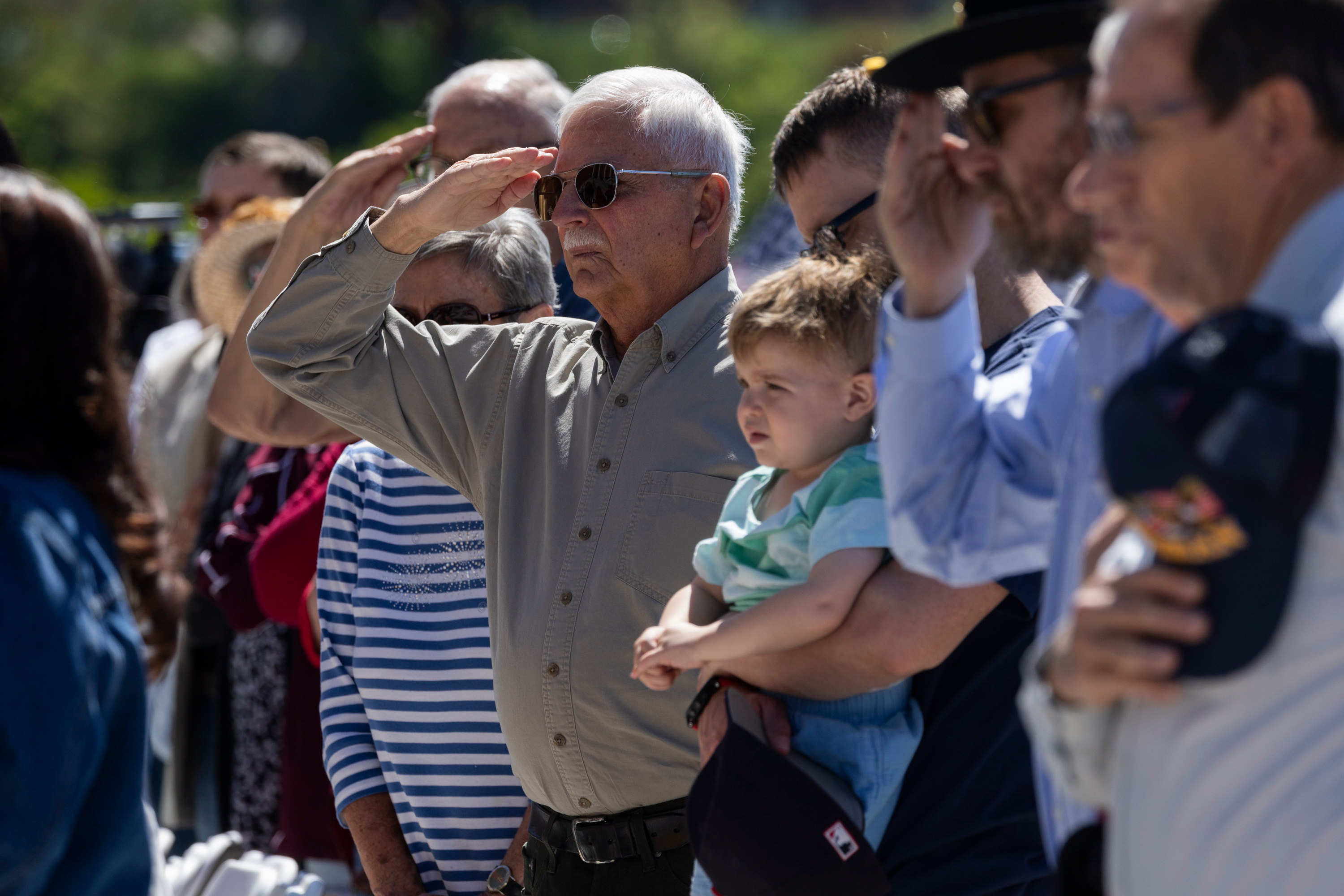 Community members salute as the National Anthem is played during the Memorial Day commemoration at the Utah Capitol in Salt Lake City on Monday.