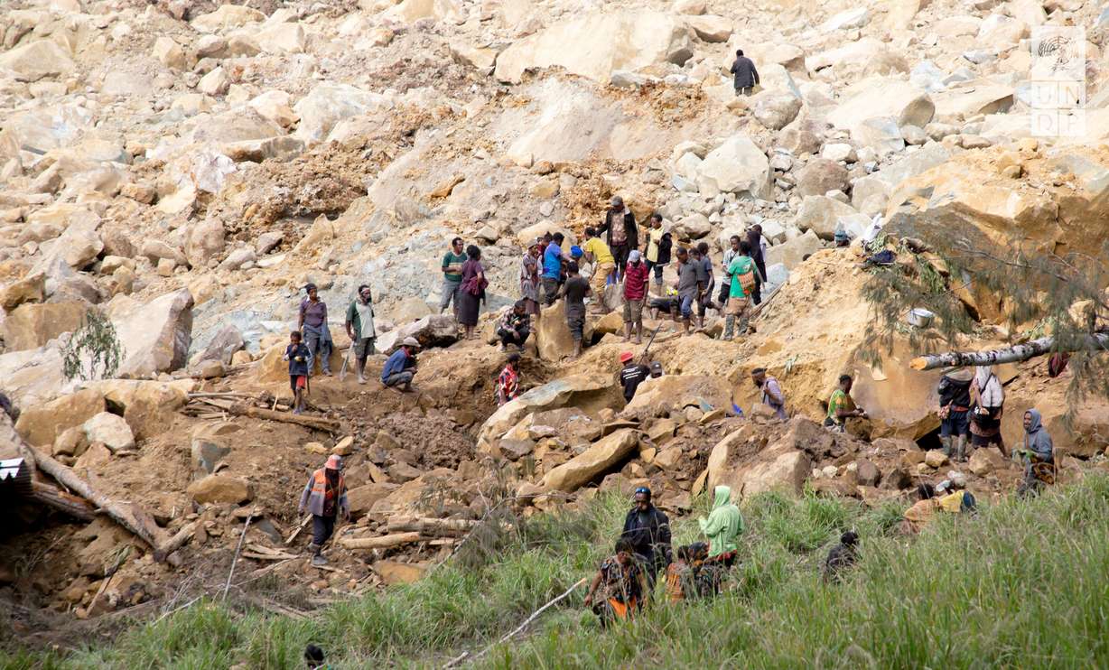 People clear an area at the site of a landslide in Yambali village, Enga Province, Papua New Guinea, Monday.