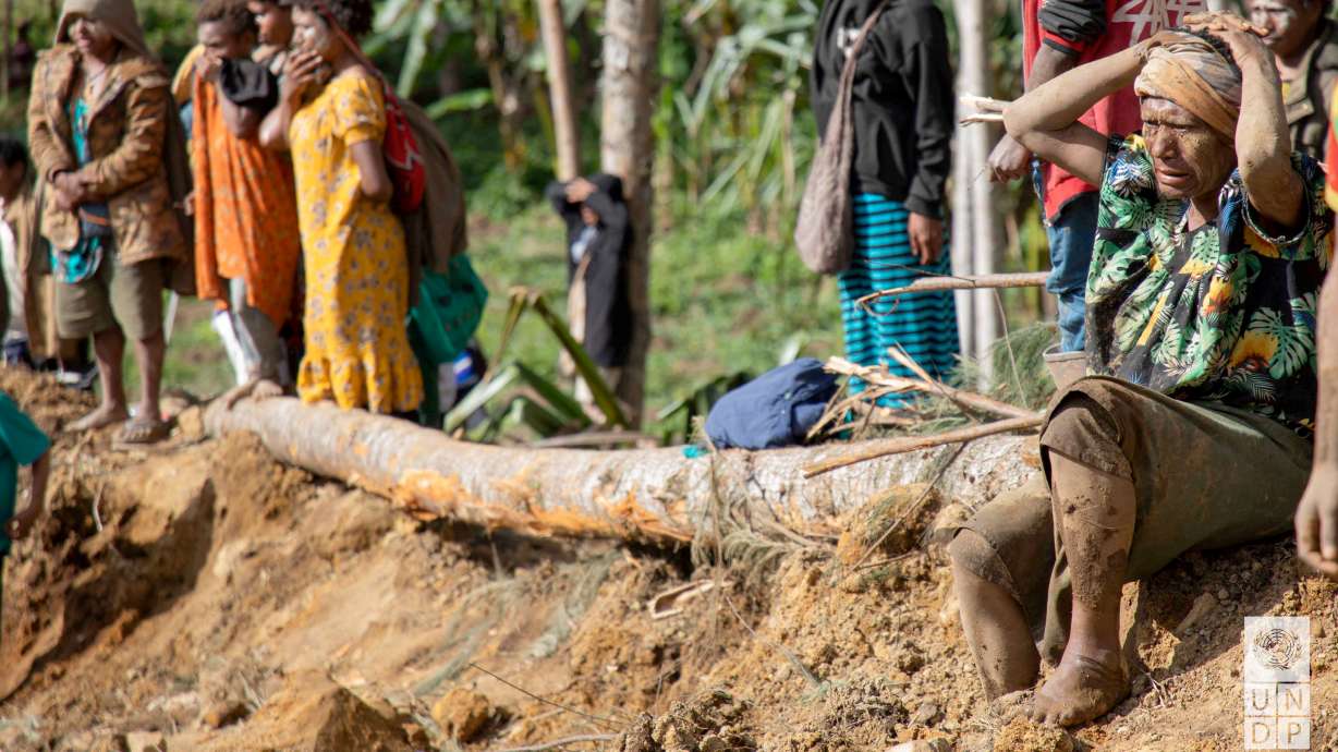 Onlookers react as people clear an area at the site of a landslide in Yambali village, Enga Province, Papua New Guinea, Monday. The death toll from Friday's landslide may be higher than authorities feared as thousands may remain buried.