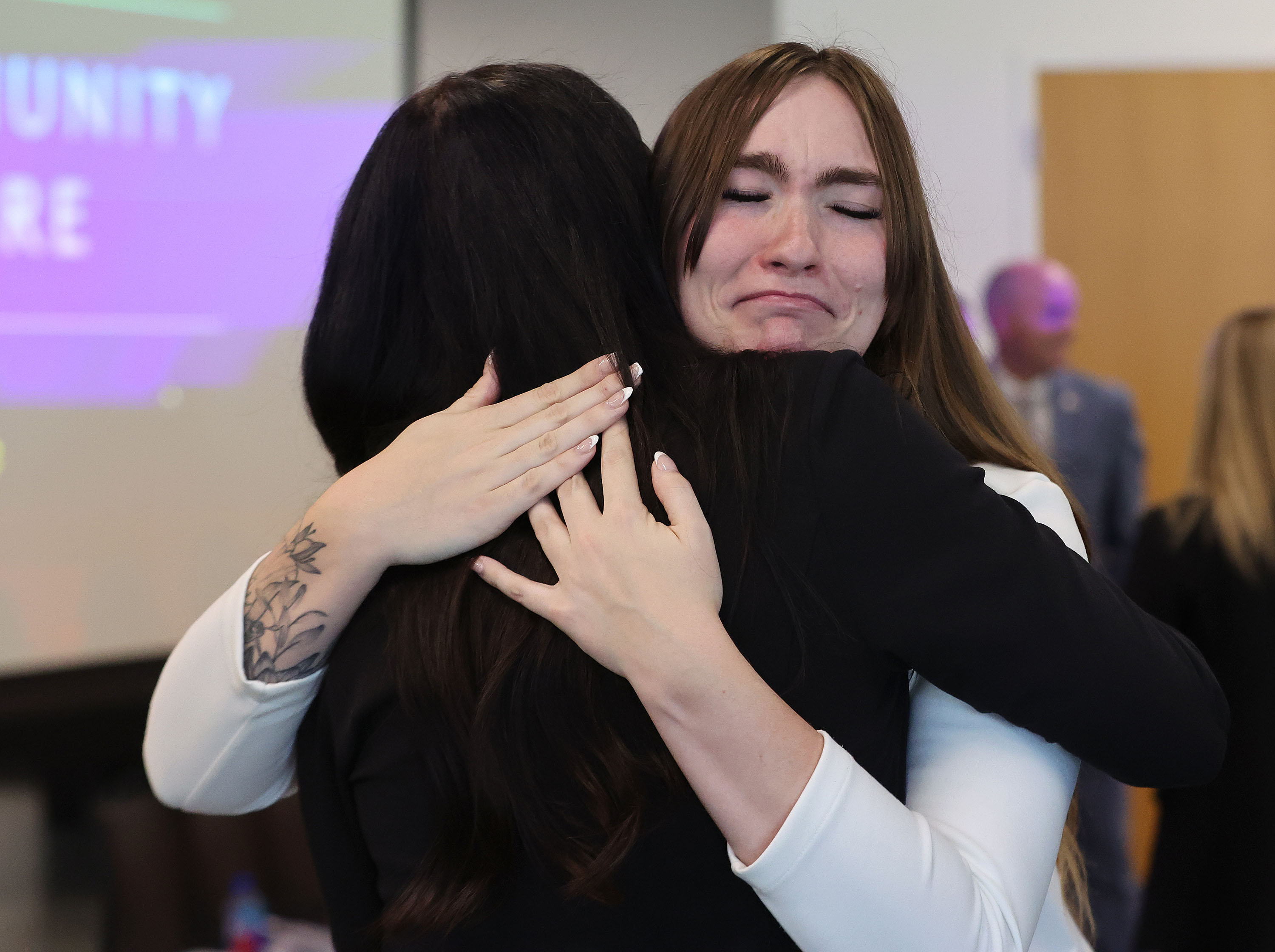 Natalie Clark, a former foster care young adult, gets a hug after speaking during a Utah Foster Care press conference in Lehi on Tuesday.