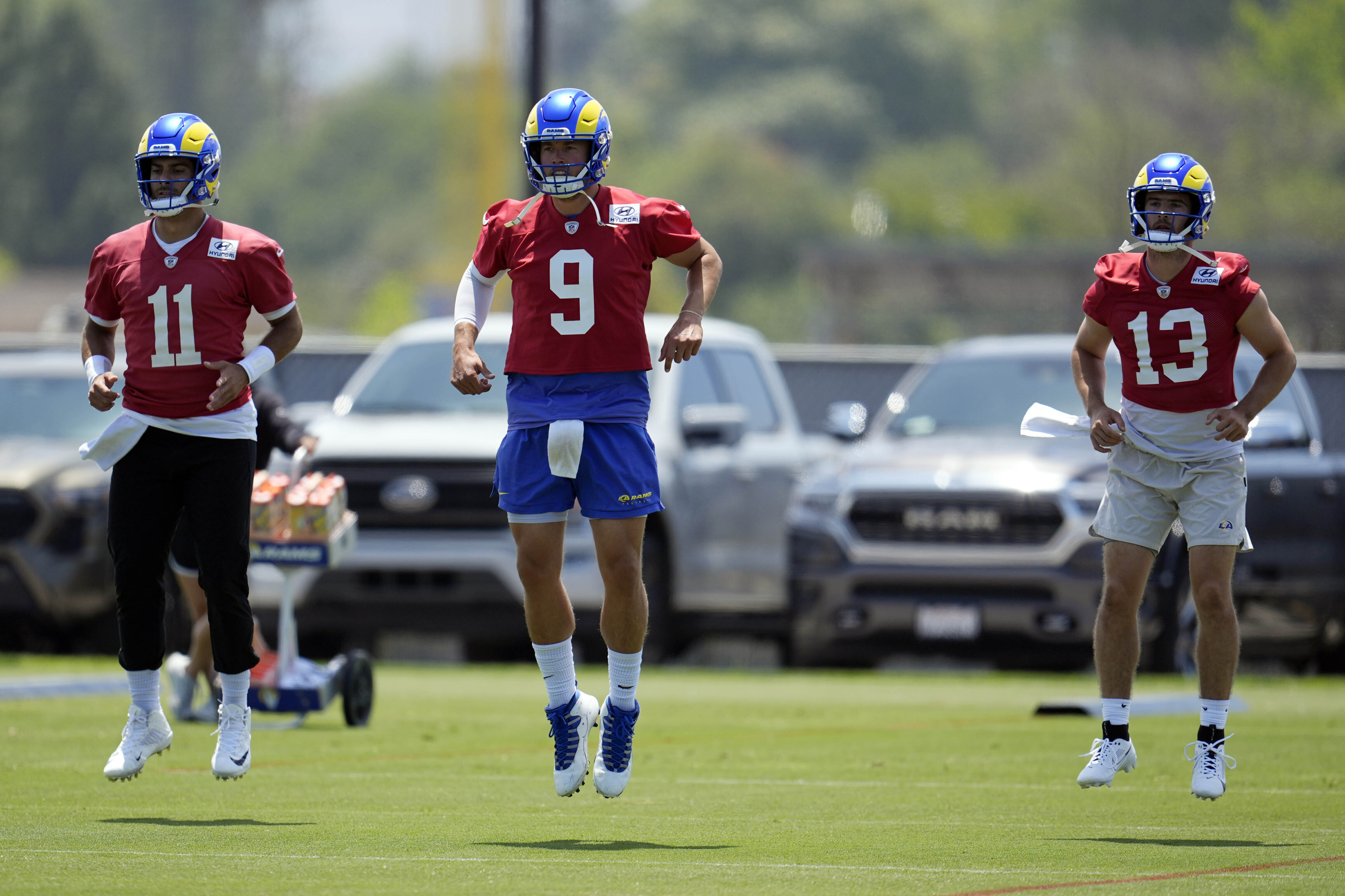Los Angeles Rams quarterback Jimmy Garoppolo, left, Matthew Stafford, center, and Stetson Bennett warm up during the NFL football team's organized team activities Tuesday, May 28, 2024, in Thousand Oaks, Calif.