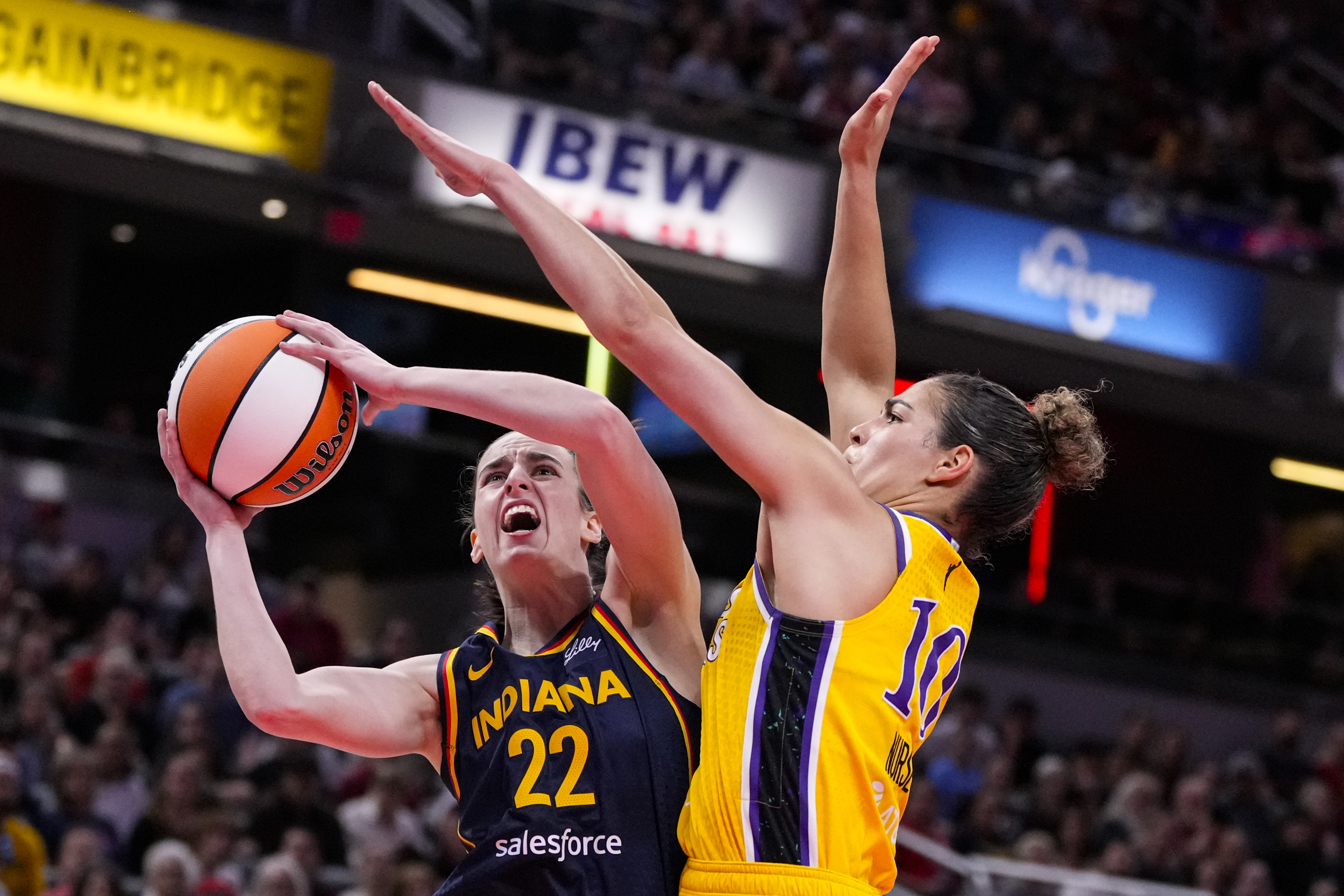 Indiana Fever guard Caitlin Clark (22) shoots around Los Angeles Sparks guard Kia Nurse (10) in the first half of a WNBA basketball game in Indianapolis, Tuesday, May 28, 2024.