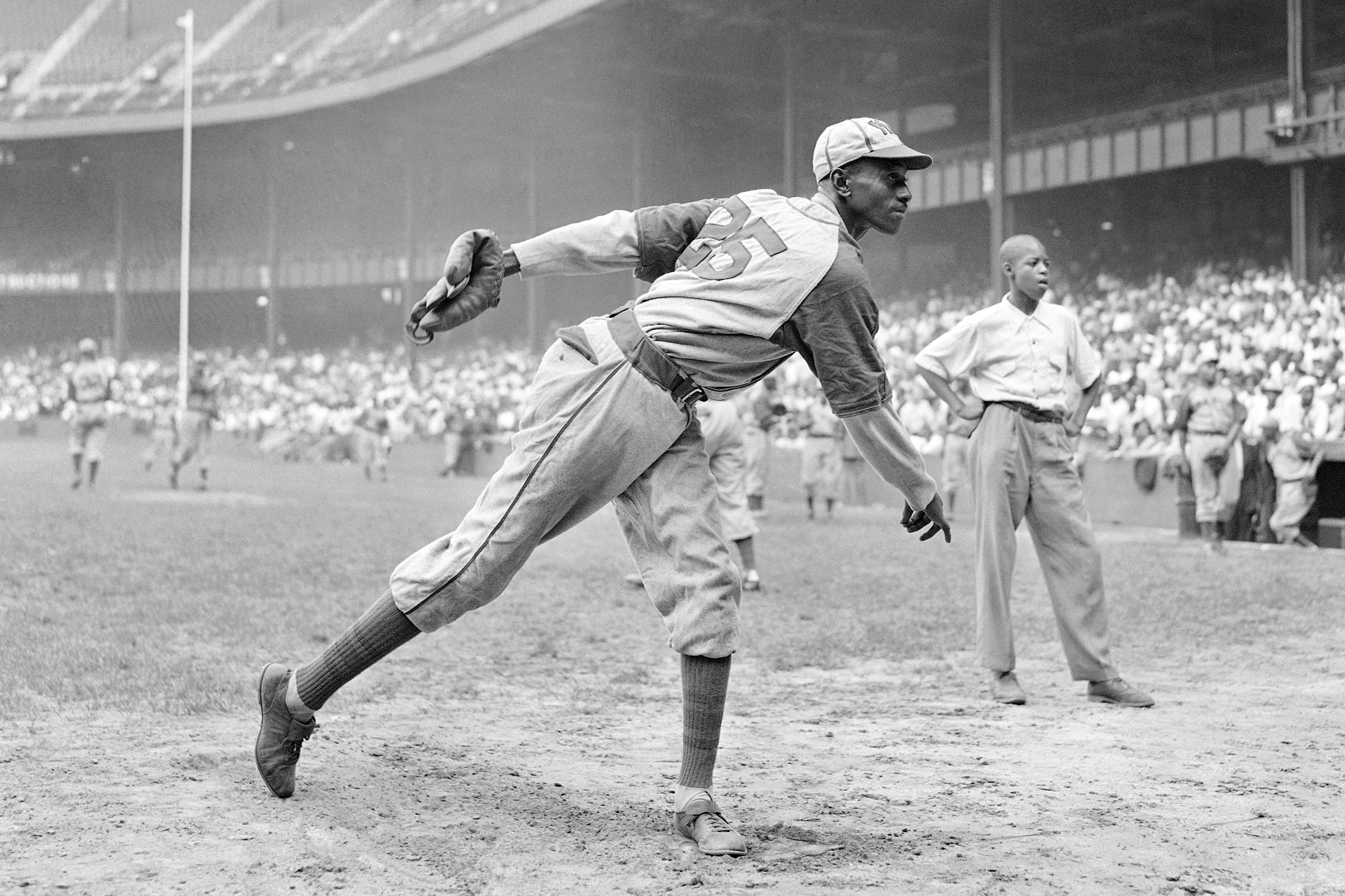 FILE - In this Aug. 2, 1942, file photo, Kansas City Monarchs pitcher Leroy Satchel Paige warms up at New York's Yankee Stadium before a Negro League game between the Monarchs and the New York Cuban Stars. Major League Baseball said Tuesday, May 28, 2024, that it has incorporated records for more than 2,300 Negro Leagues players following a three-year research project. Paige’s 1.01 ERA for the 1944 Kansas City Monarchs of the Negro American League ranks third since ERA became an official stat in the National League in 1912 and American League in 1913. Paige was also credited with 28 Negro Leagues wins, raising his career total to 125.