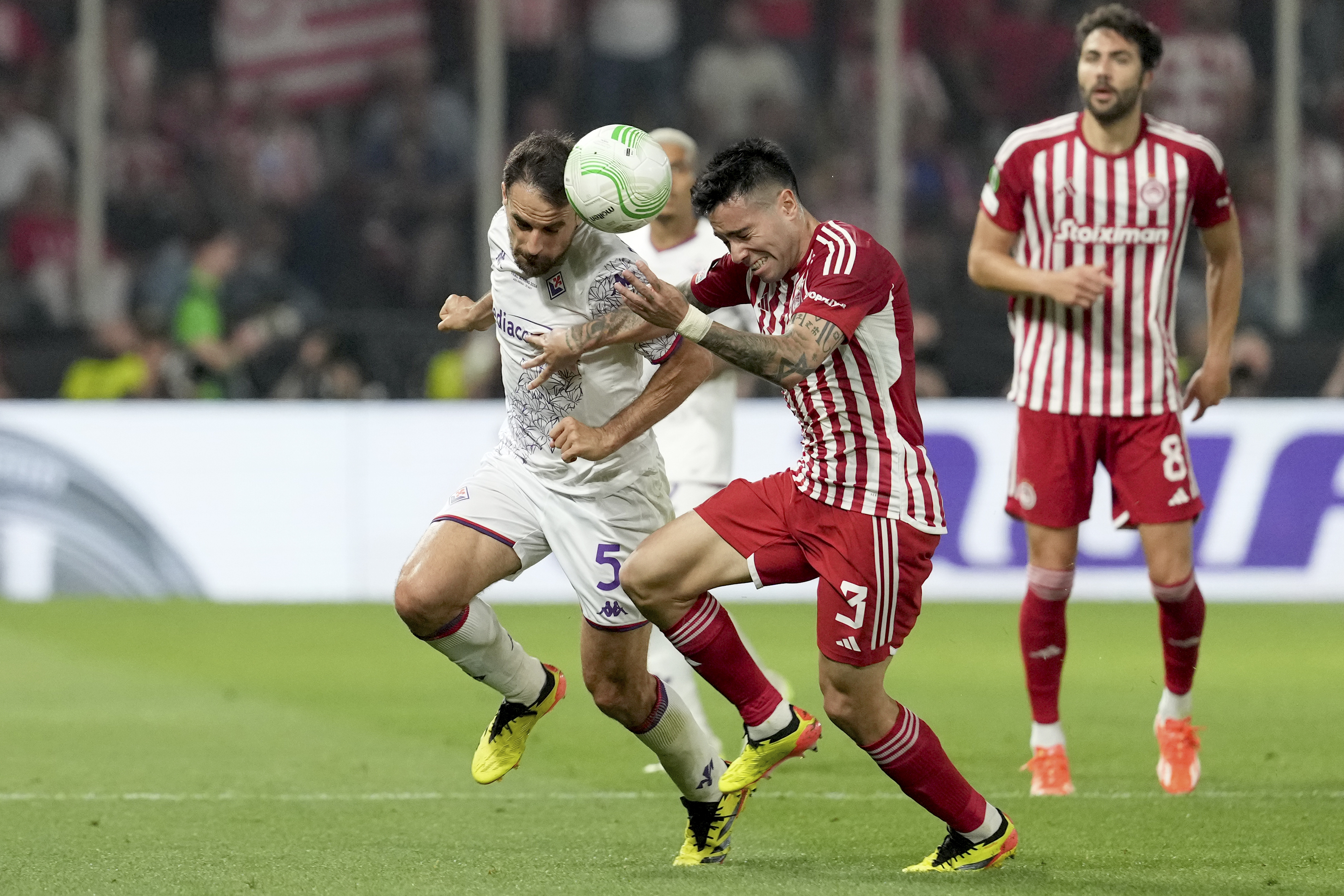Fiorentina's Giacomo Bonaventura, left, vies for the ball with Olympiacos' Francisco Ortega during the Conference League final soccer match between Olympiacos FC and ACF Fiorentina at OPAP Arena in Athens, Greece, Wednesday, May 29, 2024. 