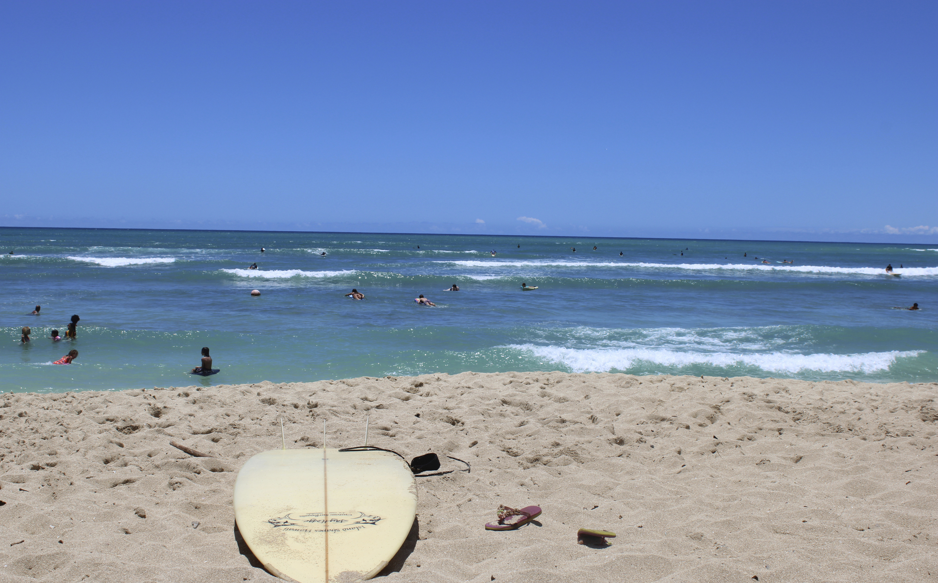 FILE - A surfboard lies on the sand on the sand at a beach known as White Plains in Ewa Beach, Hawaii, May 12, 2023. A judge has halted plans for an artificial wave pool until developers can revise an environmental assessment to address concerns raised by Native Hawaiians and others who say the project is unnecessary in the birthplace of surfing and a waste of water.