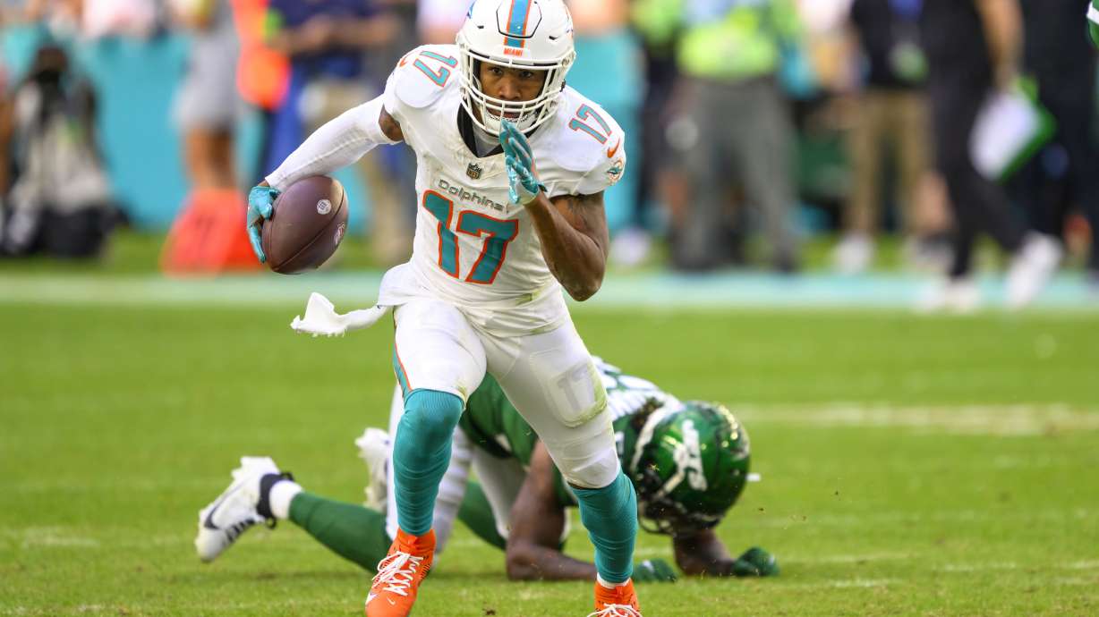 FILE - Miami Dolphins wide receiver Jaylen Waddle (17) runs with the ball past New York Jets linebacker Quincy Williams (56) during an NFL football game, Sunday, Dec 17, 2023, in Miami Gardens, Fla. Waddle has agreed to a three-year, $84.75 million contract extension with the Miami Dolphins, a person familiar with the deal told The Associated Press.