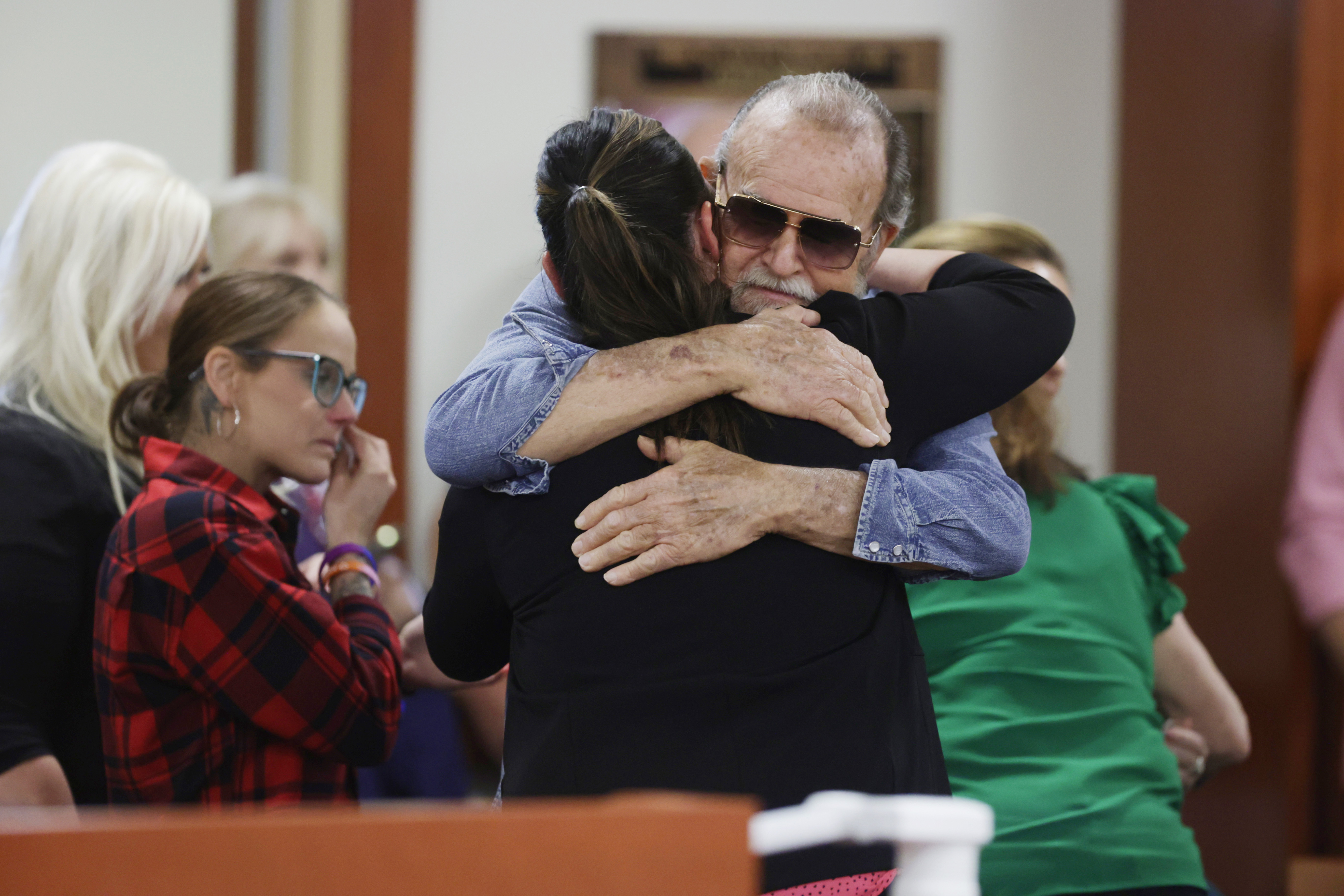 Larry Woodcock, gets a hug after the verdict in the Chad Daybell murder trial was read on Thursday. Daybell was convicted of killing his wife and his new girlfriend's two youngest kids — including Woodcock's grandson.