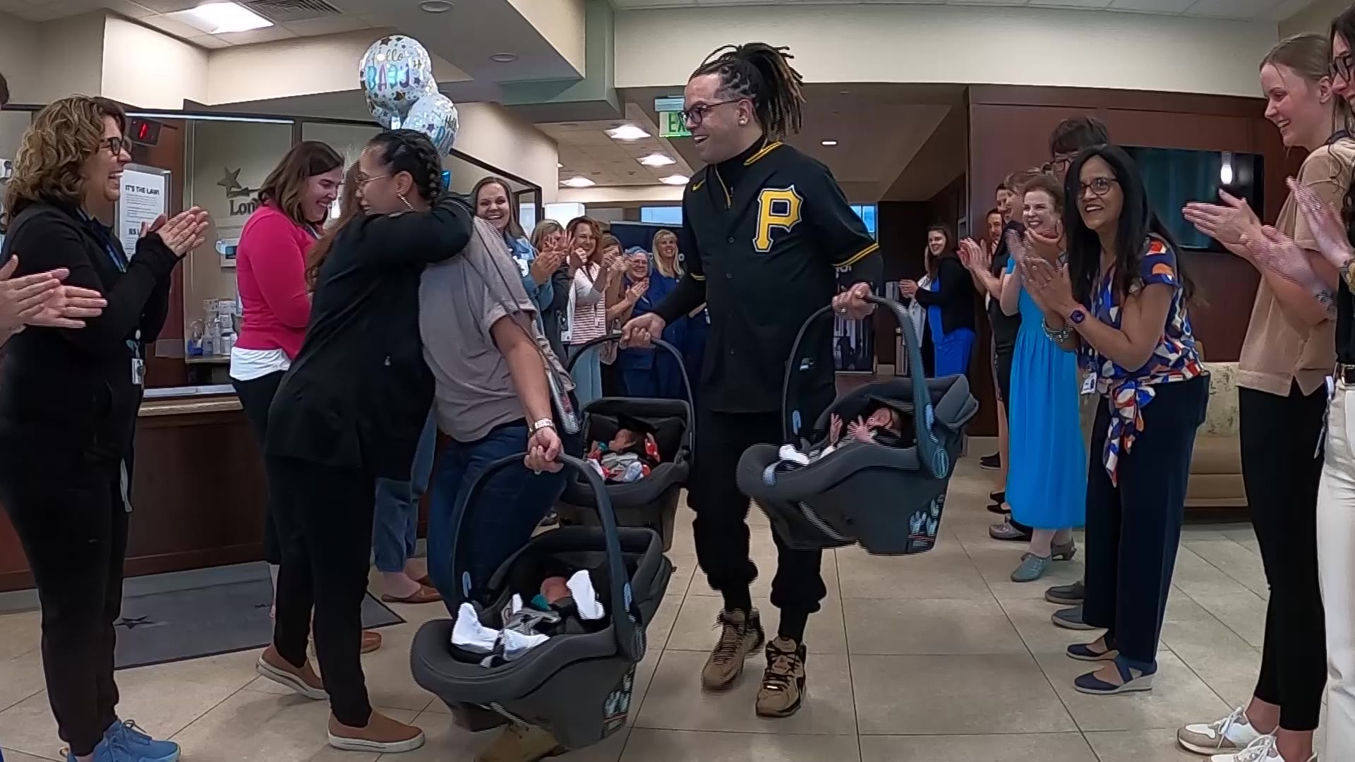 Kahea Benitez-Kauo and her husband, Hector Benitez, walk out of the Lone Peak Hospital as they are cheered on by hospital staff.