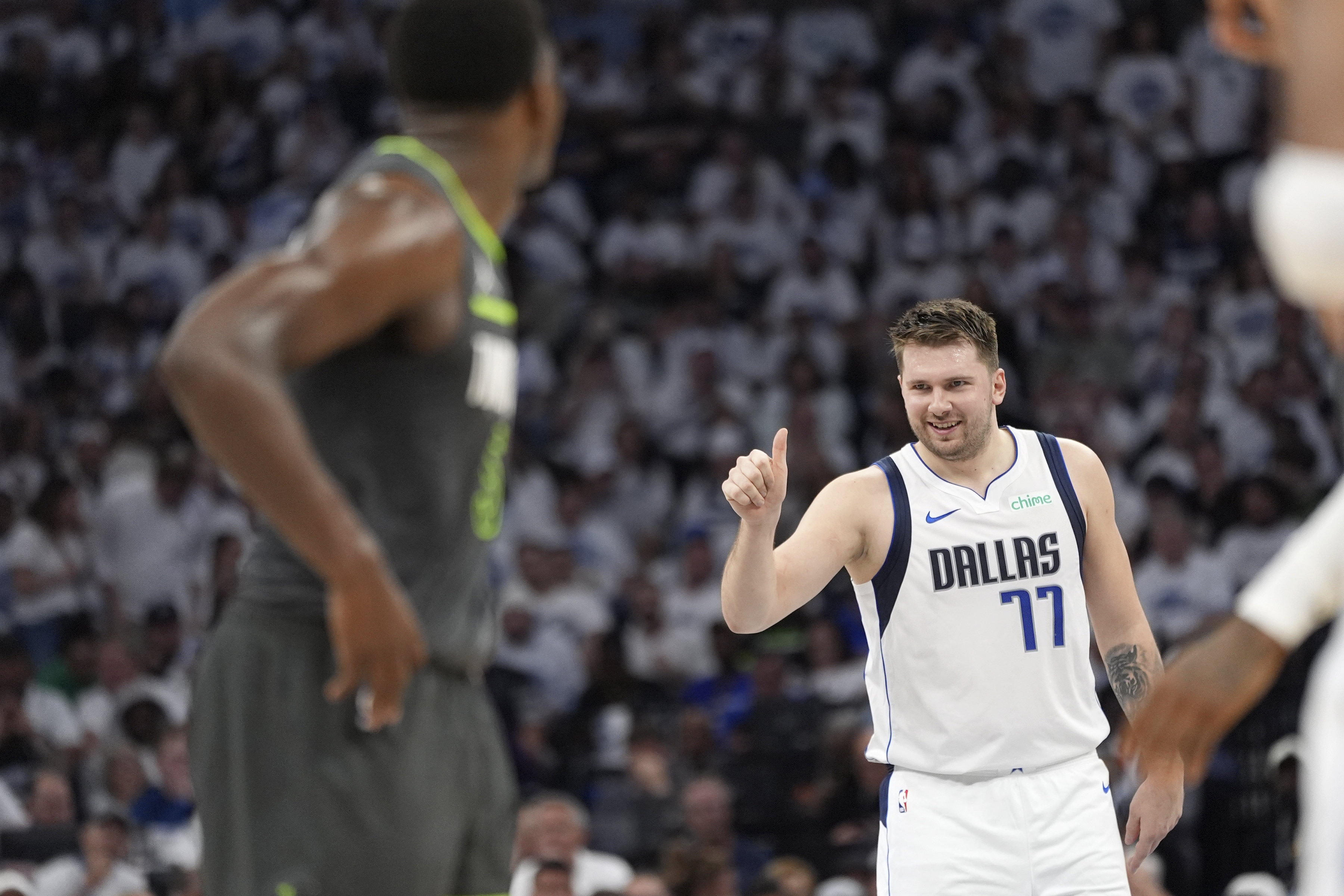 Dallas Mavericks guard Luka Doncic (77) celebrates his score as Minnesota Timberwolves guard Anthony Edwards, left, looks on during the first half of Game 5 of the Western Conference finals in the NBA basketball playoffs, Thursday, May 30, 2024, in Minneapolis. 