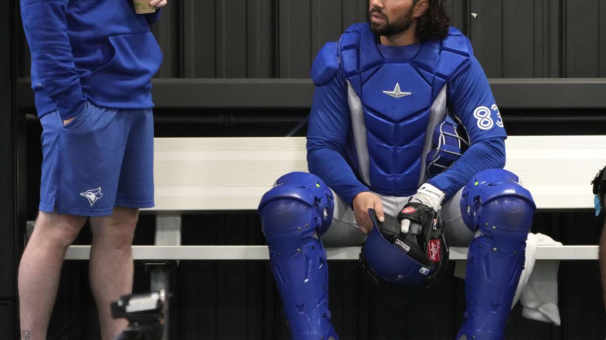 FILE - Toronto Blue Jays catcher Payton Henry, right, sits in the bullpen during a baseball spring training workout Feb. 18, 2024, in Dunedin, Fla. Current Buffalo Bisons catcher Henry was hospitalized Friday, May 31, 2024, after he was struck by a batter's backswing and carted off the field on a stretcher.