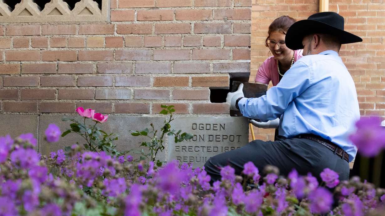 Hope Eggett, museum curator at Union Station, and Dave Tingey, Grand Master of Masons in Utah, pull a time capsule out of the cornerstone at a ceremony at Union Station in Ogden on May 31. The time capsule was placed 100 years ago, on May 31, 1924, during the building of the structure.