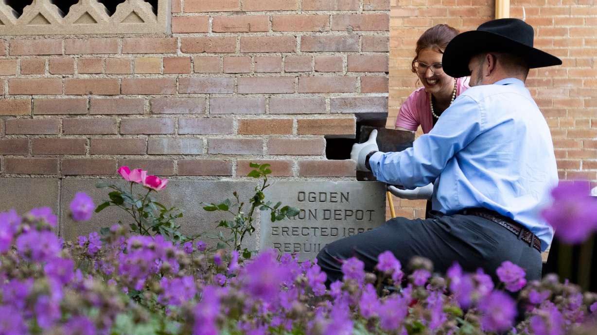 Hope Eggett, museum curator at Union Station, and Dave Tingey, grand master of masons in Utah, pull a time capsule out of the cornerstone at a ceremony at Union Station in Ogden on Friday. The time capsule was placed 100 years ago, on May 31, 1924, during the building of the structure.