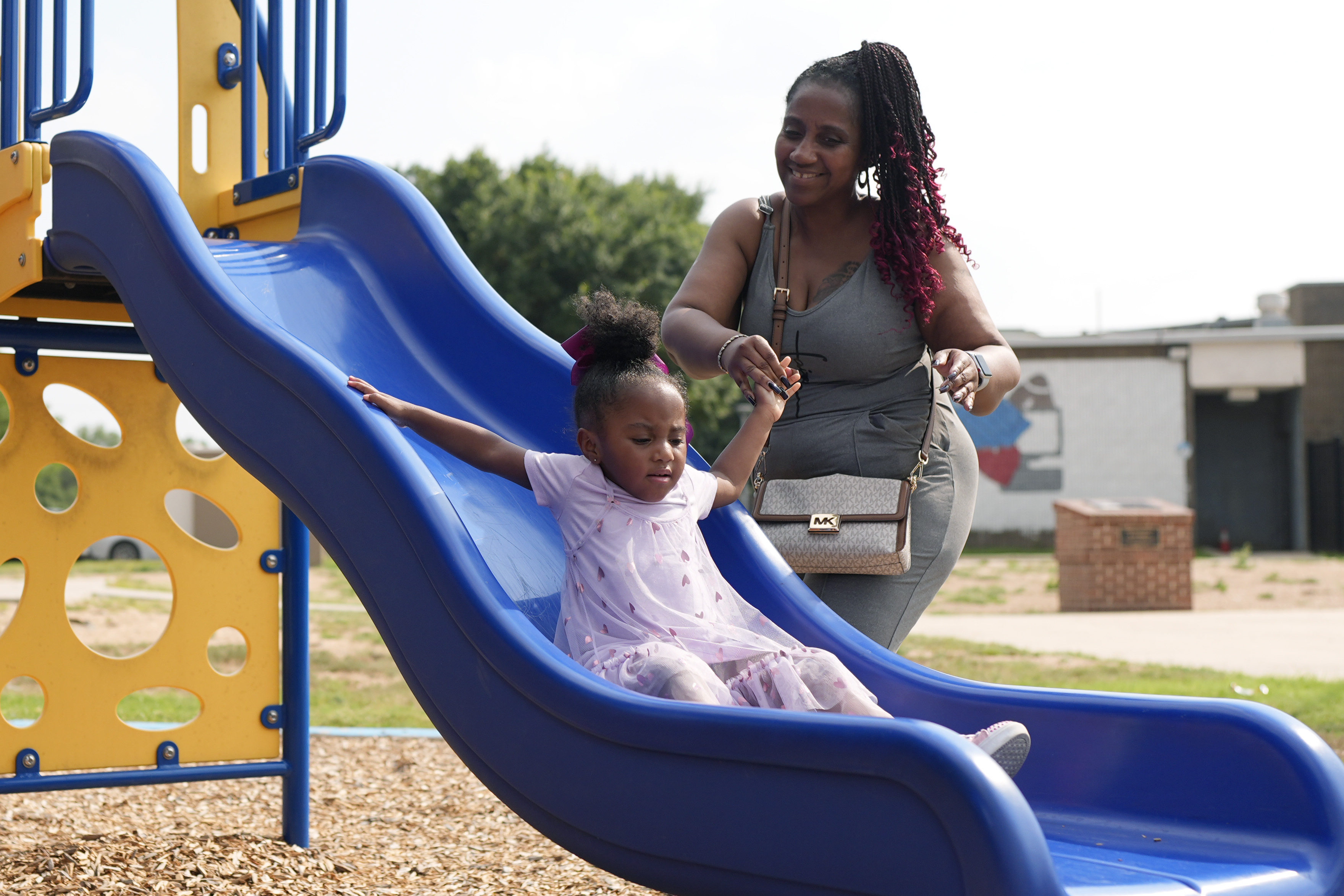 Tamika Davis, right, spends time with her daughter, Shanara, 3, at MLK Park in San Antonio, Thursday. Davis said friends and family watched her kids for most of her doctor visits during treatment last year for colon cancer. But she couldn't afford additional child care, and she didn't know where to look for assistance.