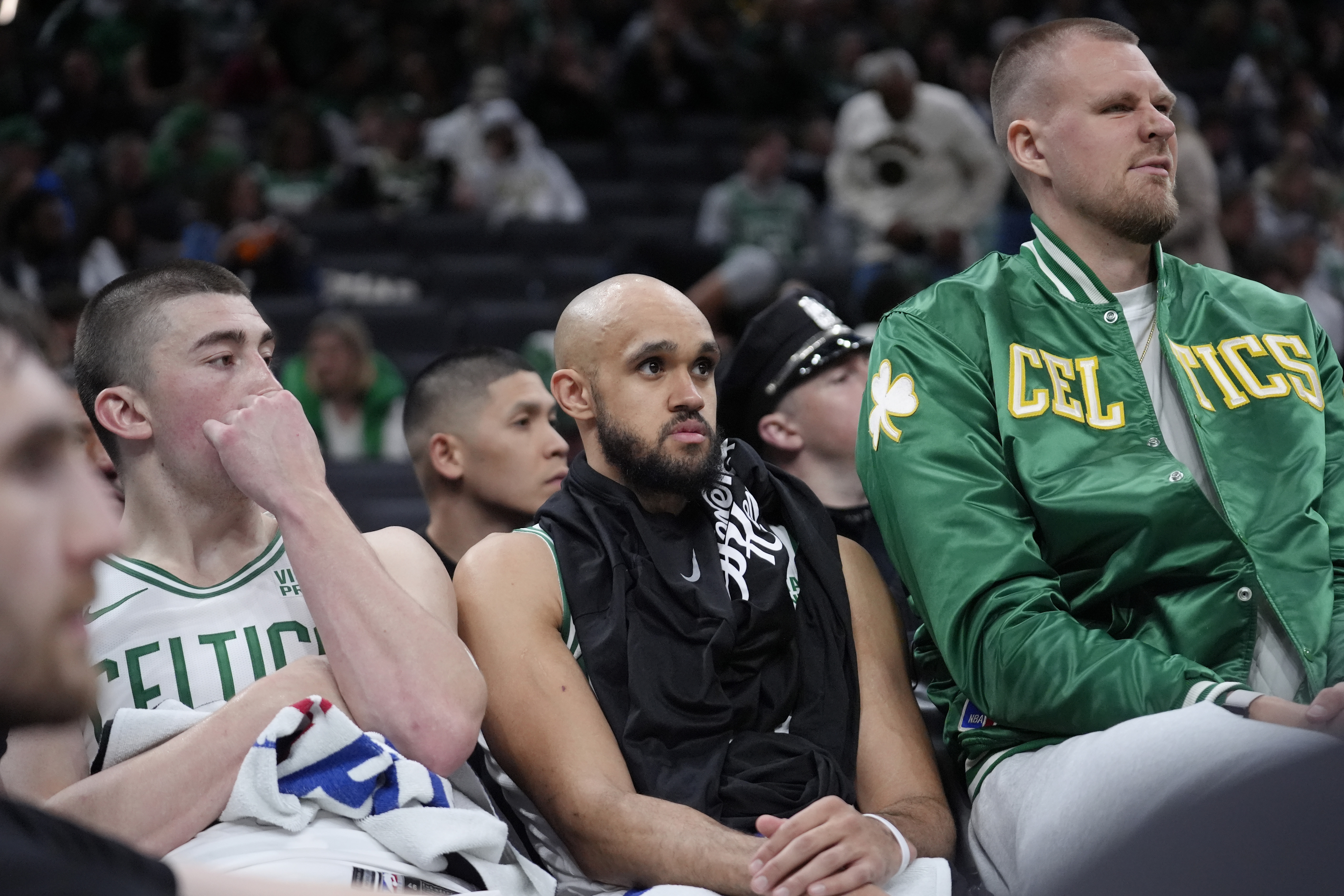 Boston Celtics guard Payton Pritchard, left, guard Derrick White, center, and center Kristaps Porzingis, right, watch from the bench as the Cleveland Cavaliers lead the Celtics during the second half of Game 2 of an NBA basketball second-round playoff series, Thursday, May 9, 2024, in Boston. 