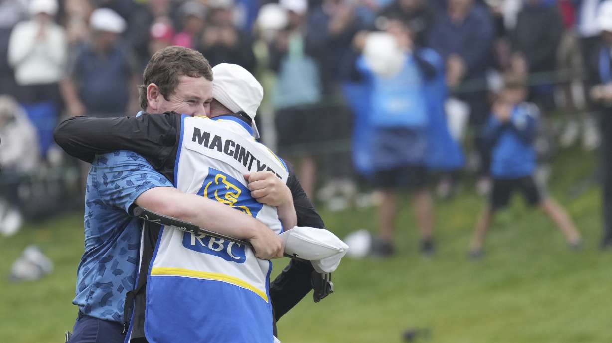 Scotland's Robert MacIntyre celebrates with his father Dougie MacIntyre after winning the Canadian Open golf tournament in Hamilton, Ontario, Sunday, June 2, 2024.