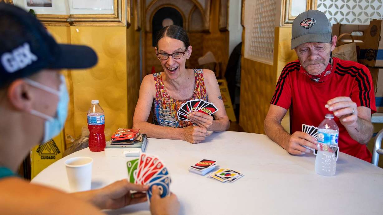 Morgan Coder, left, plays Uno with Kathleen Stoughton, 64, center, and Kathleen's husband Kim, 61, at a cooling center in Portland, Oregon in 2021. Almost one set of Uno was sold in the U.S. every second last year, according to Mattel, its publisher.