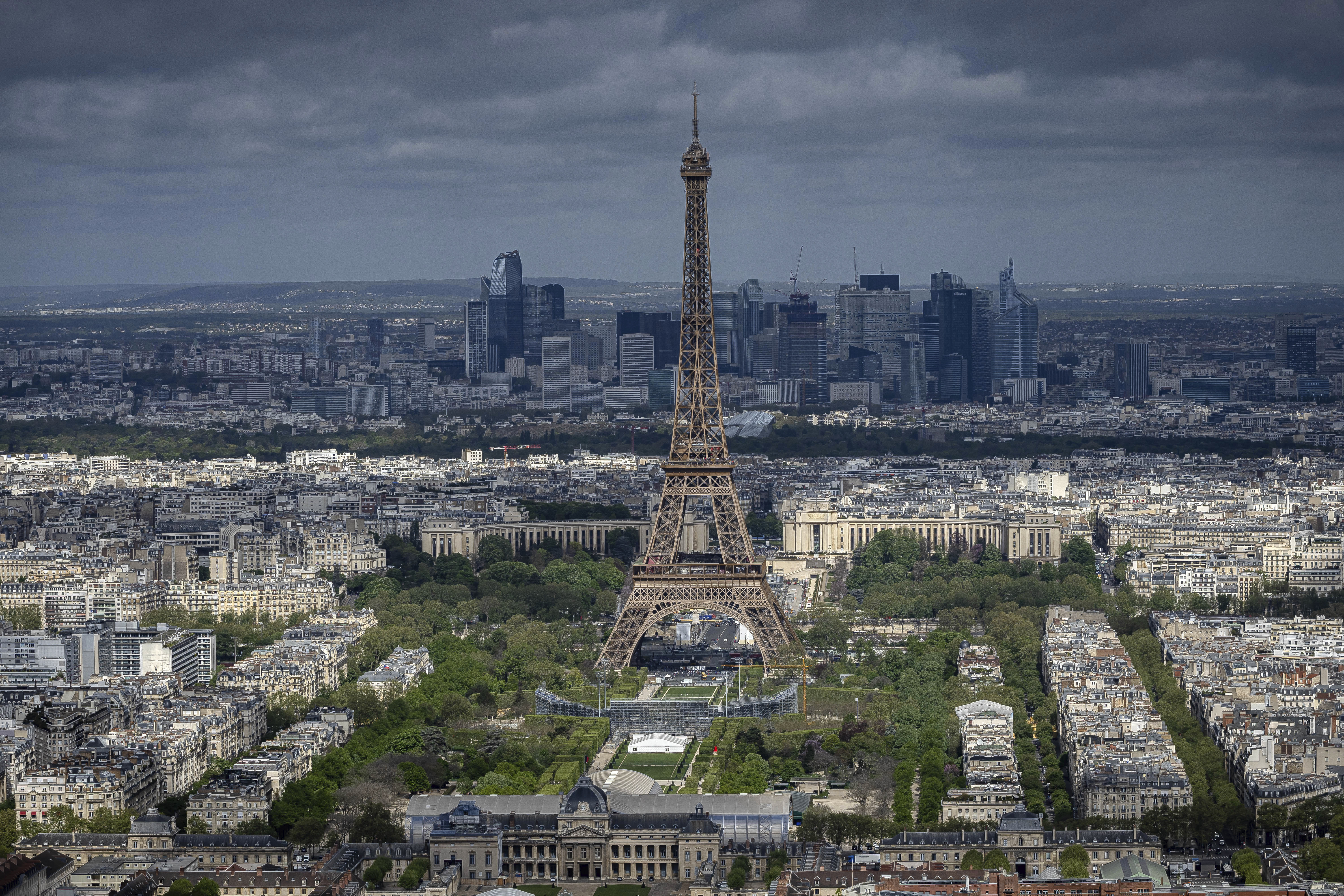 FILE - Stands are under construction on the Champ-de-Mars in front of the Eiffel Tower, Monday, April 15, 2024 in Paris. La Dame de Fer (The Iron Lady) needs no introduction and is still going strong at 1235 years old. Men's and women's volleyball players get to compete at the feet of the 330-meter tower and will be watched by nearly 13,000 fans at the temporary Eiffel Tower Stadium. 