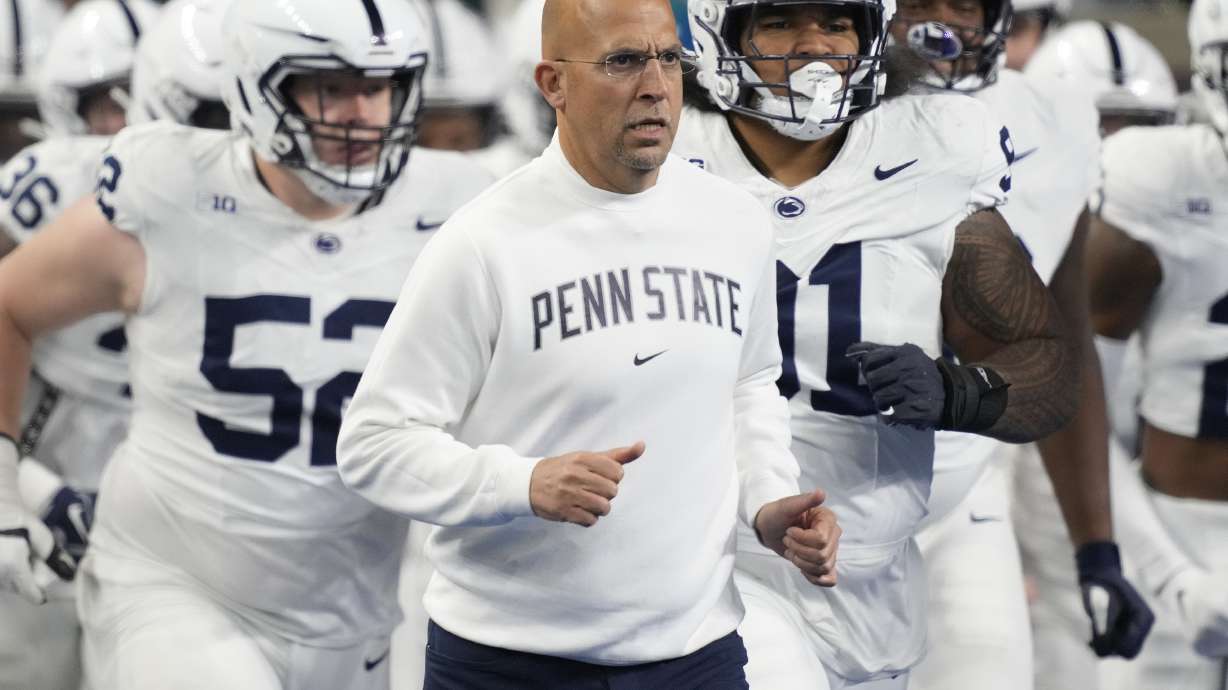 FILE - Penn State head coach James Franklin, center, runs out with his team before an NCAA college football game against Michigan State, Nov. 24, 2023, in Detroit. An internal review by Penn State in 2019 found evidence of “friction” between football coach James Franklin and a now-former team doctor. However, it could not determine whether Franklin violated NCAA rules or Big Ten standards by interfering with medical decisions.
