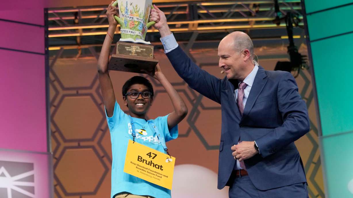 Bruhat Soma, 12, of Tampa, Fla., accepts the trophy from E.W. Scripps Company President and CEO Adam Symson after winning the Scripps National Spelling Bee, in Oxon Hill, Md., May 30.