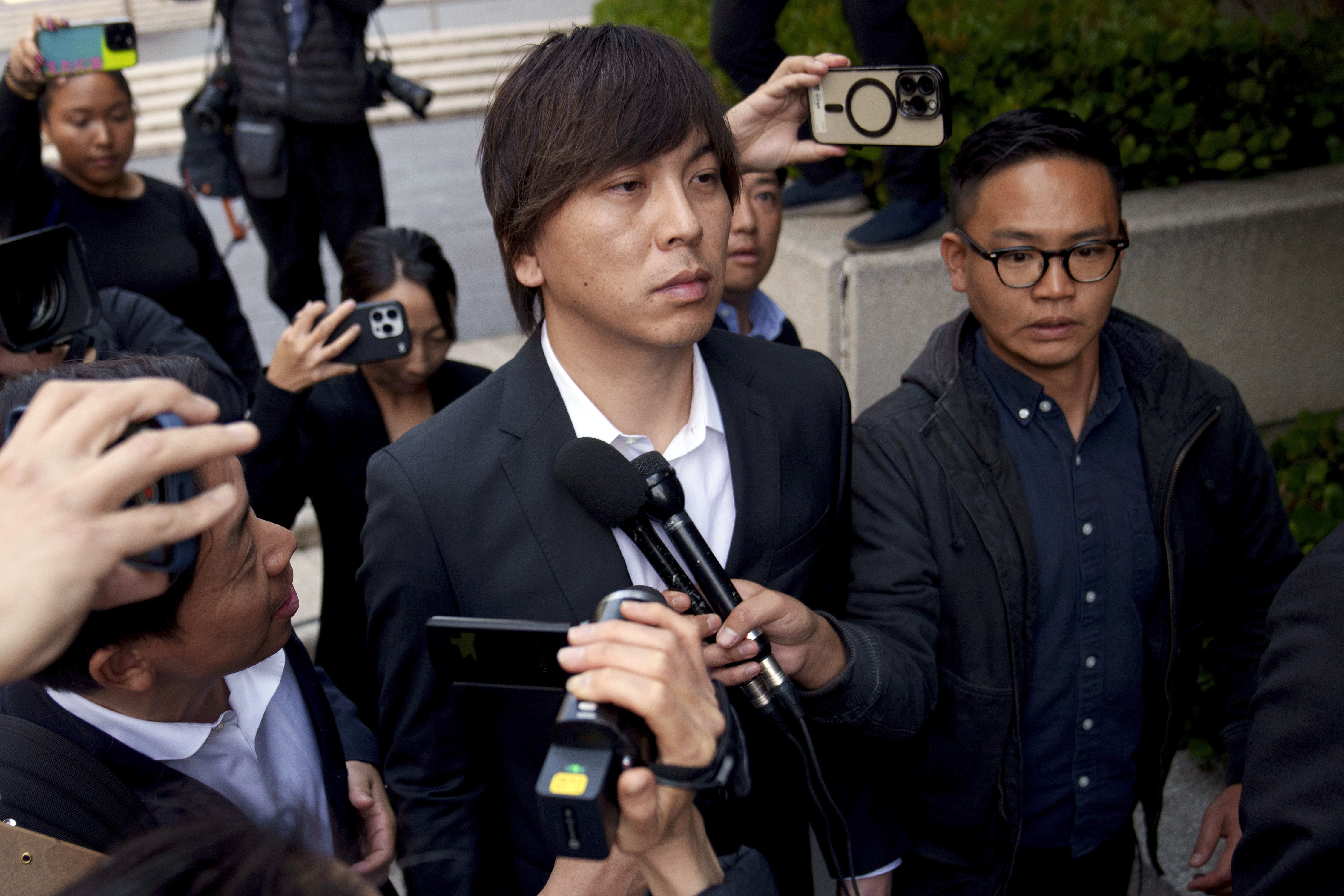 FILE - Ippei Mizuhara, center, the former longtime interpreter for the Los Angeles Dodgers baseball star Shohei Ohtani, leaves federal court following his arraignment, Tuesday, May 14, 2024, in Los Angeles. Mizuhara is scheduled to plead guilty Tuesday, June 4, 2024, to bank and tax fraud in a sports betting case where he is expected to admit to stealing nearly $17 million from the Japanese baseball player.