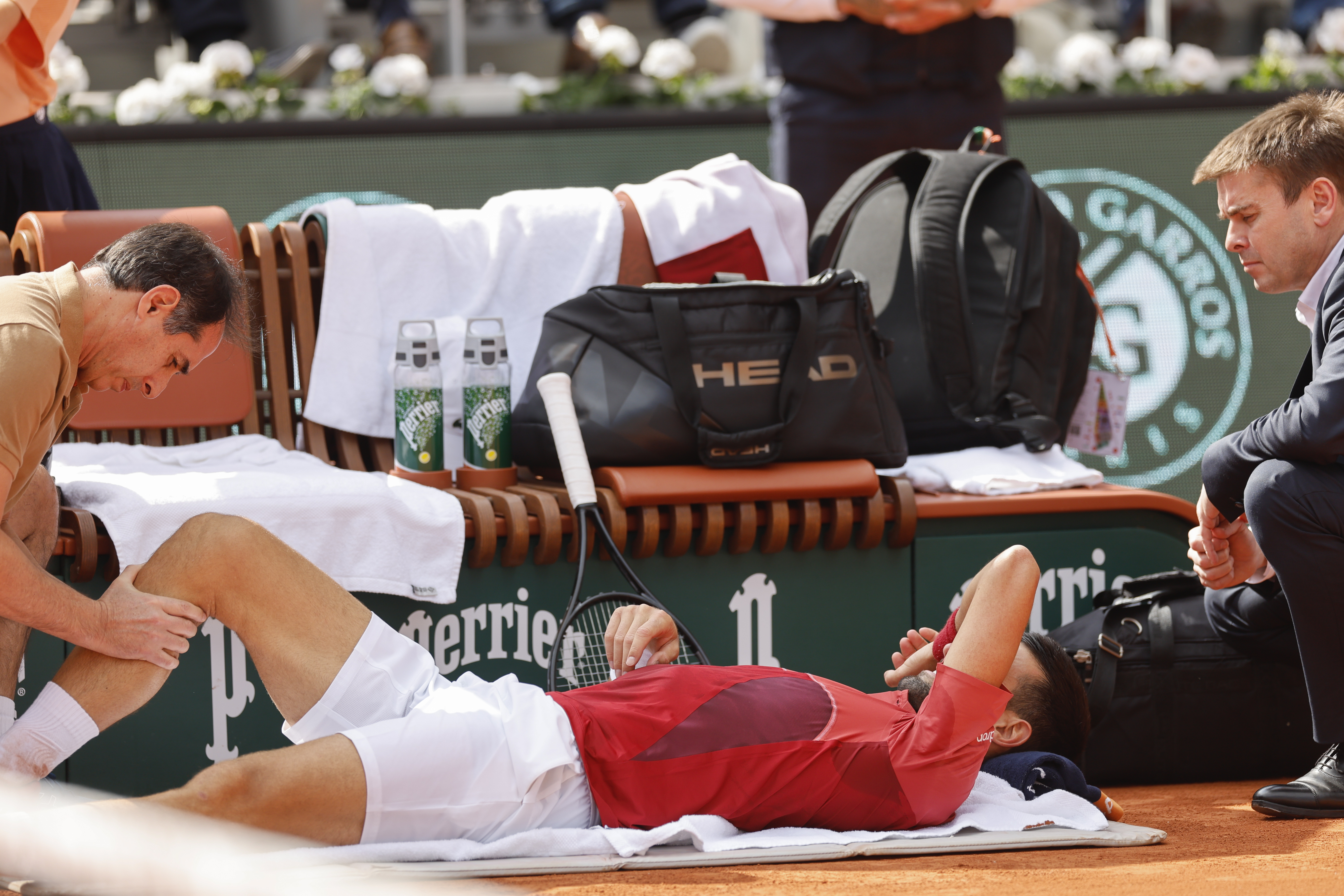 Serbia's Novak Djokovic receives medical assistance for his right knee during his fourth round match of the French Open tennis tournament against Argentina's Francisco Cerundolo at the Roland Garros stadium in Paris, Monday, June 3, 2024. 