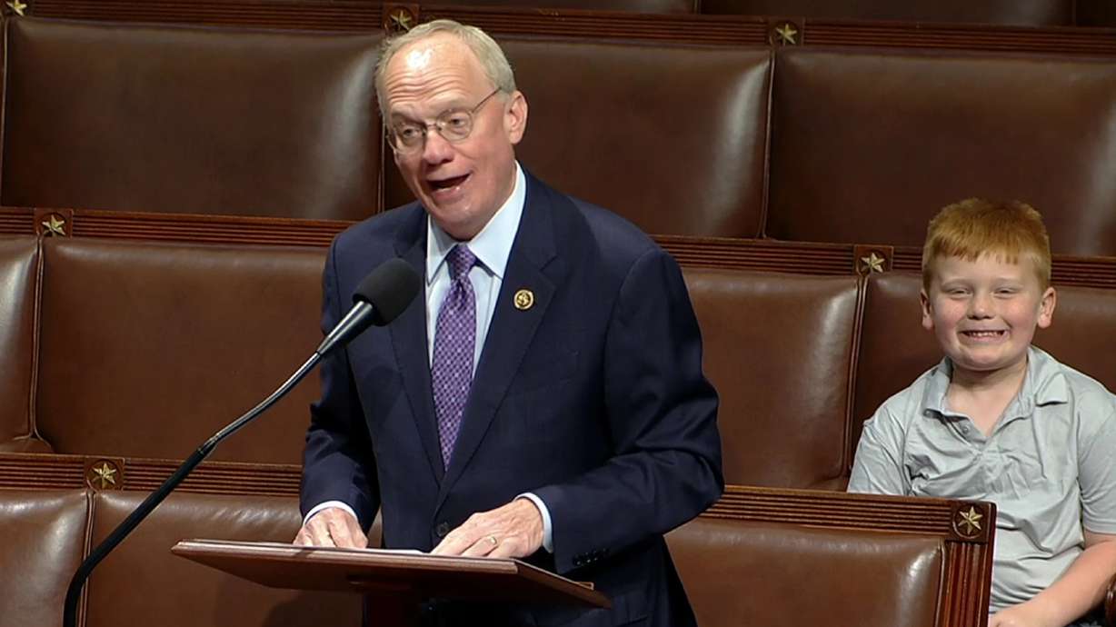 Rep. John Rose, R-Tenn., speaks on the floor of the House of Representatives Monday, in Washington, as his son Guy smiles behind.