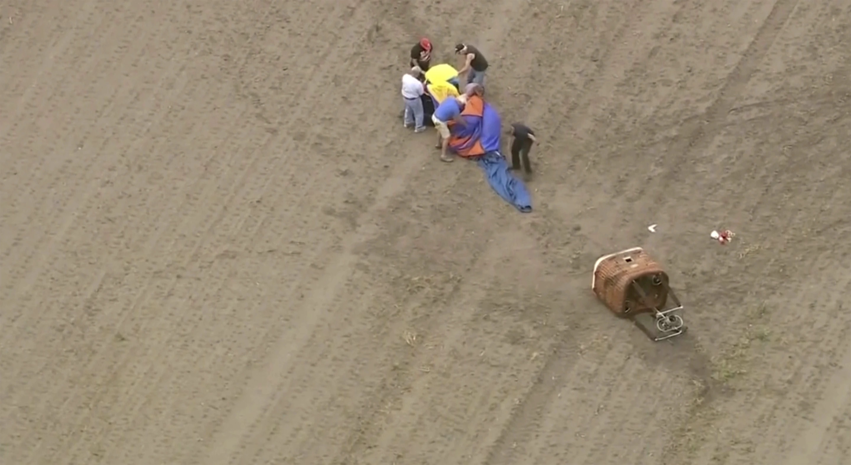 People gather near a crashed balloon on Monday in Lowell, Ind. Federal investigators are probing the hot air balloon crash in northwestern Indiana that injured three people.