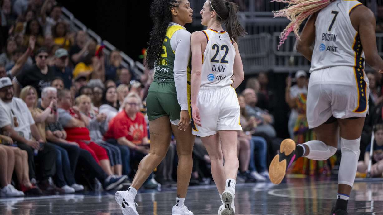 Seattle Storm guard Victoria Vivians, left, and Indiana Fever guard Caitlin Clark (22) exchange words after making contact with one another during the first half of a WNBA basketball game Thursday, May 30, 2024, in Indianapolis.