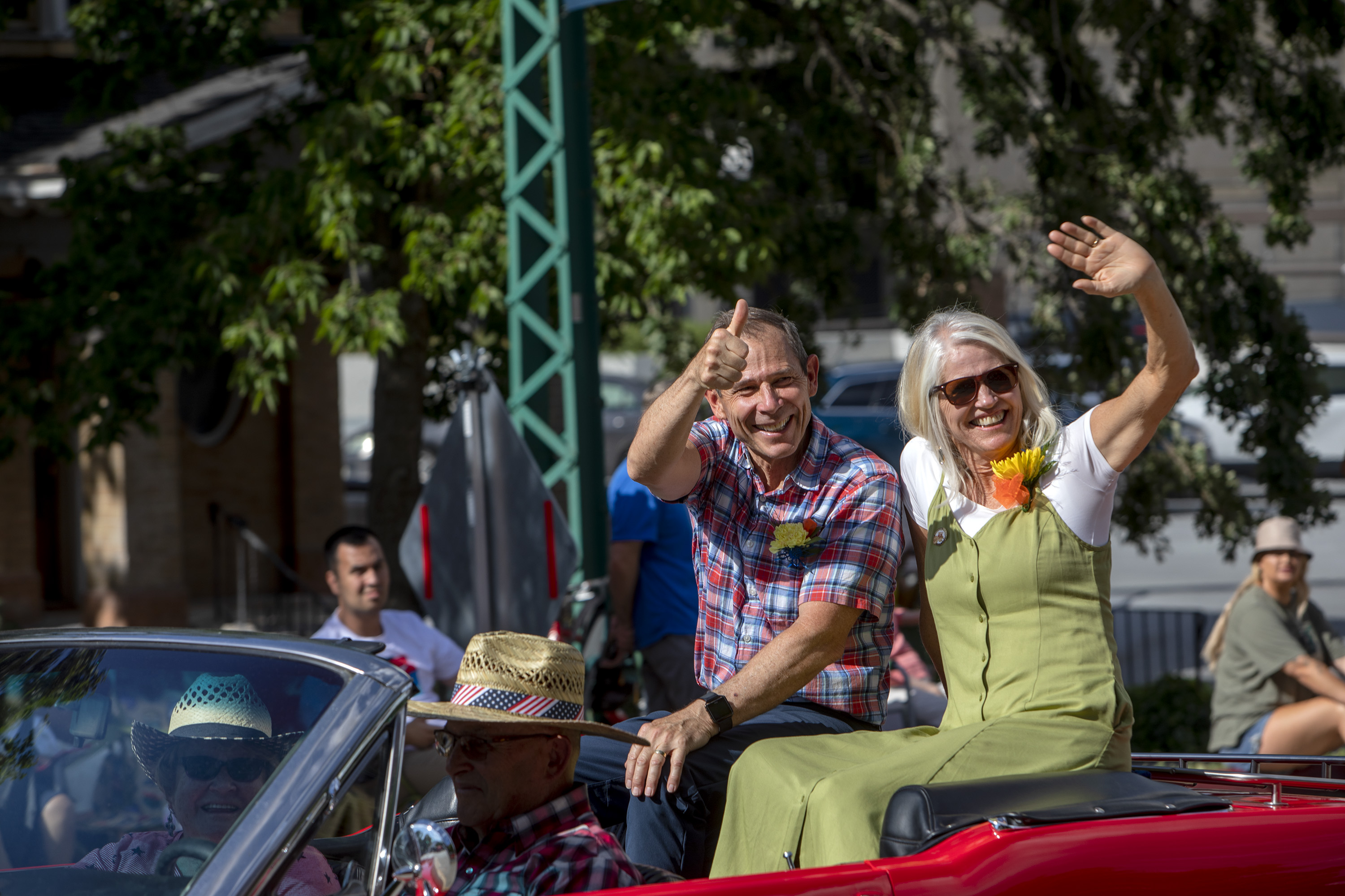 Rep. John Curtis, R-Utah, with his wife, Sue Snarr, wave to paradegoers along the Days of '47 Parade route on July 23, 2022, in Salt Lake City.