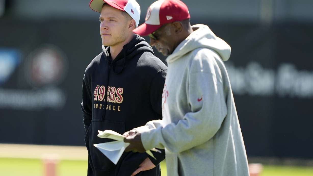 San Francisco 49ers running back Christian McCaffrey, left, watches drills with running back coach Robert Turner Jr., right, during NFL football practice in Santa Clara, Calif., Tuesday, June 4, 2024.