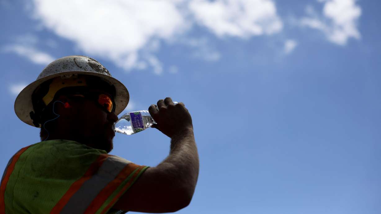 Garrett Rowser hydrates while working at a construction site in Salt Lake City on Aug. 11, 2023. Temperatures could reach as high as 104-108 degrees Fahrenheit in parts of Utah on Thursday and Friday.