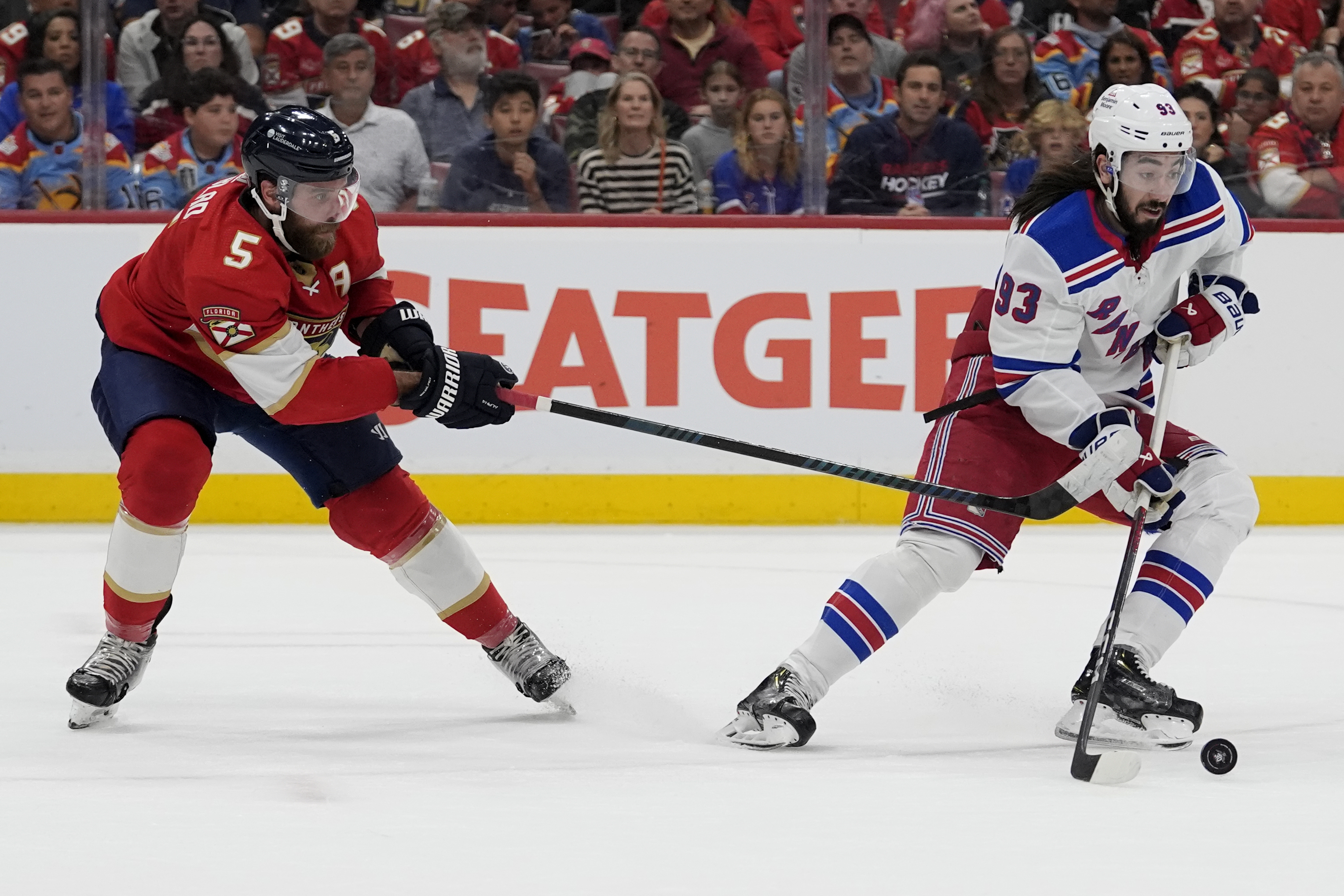 New York Rangers center Mika Zibanejad (93) skates with the puck as Florida Panthers defenseman Aaron Ekblad (5) defends during the first period of Game 6 in the Eastern Conference finals of the NHL hockey Stanley Cup playoffs Saturday, June 1, 2024, in Sunrise, Fla. 