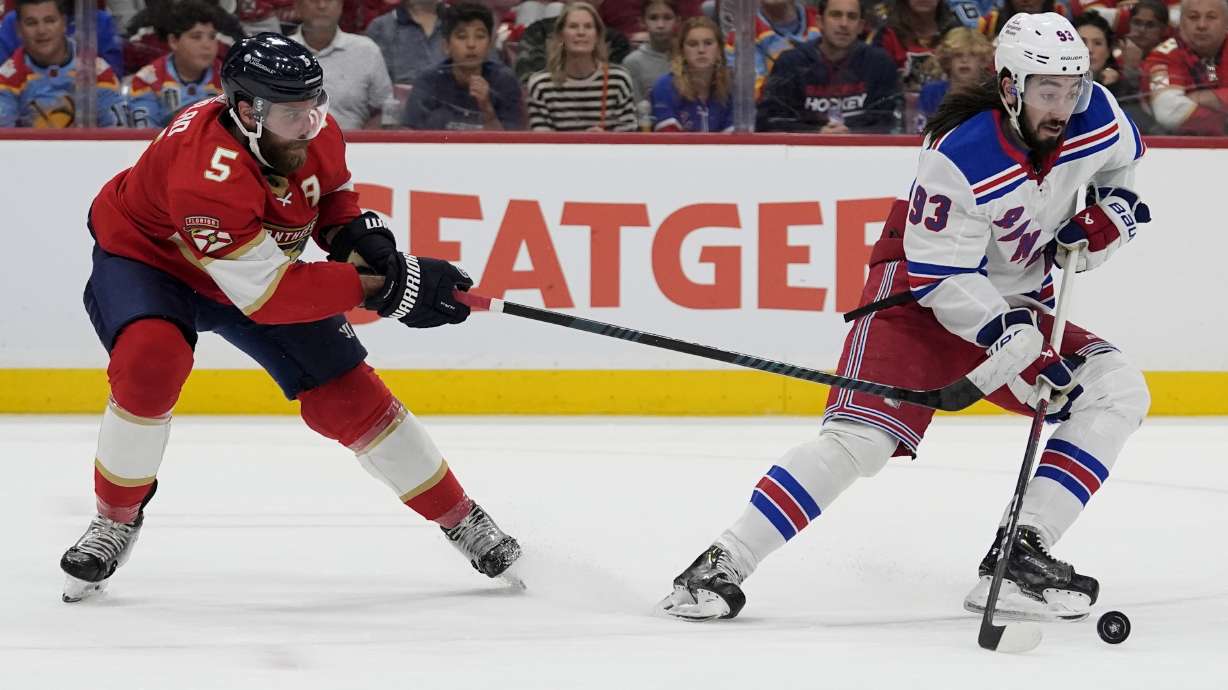 New York Rangers center Mika Zibanejad (93) skates with the puck as Florida Panthers defenseman Aaron Ekblad (5) defends during the first period of Game 6 in the Eastern Conference finals of the NHL hockey Stanley Cup playoffs Saturday, June 1, 2024, in Sunrise, Fla.