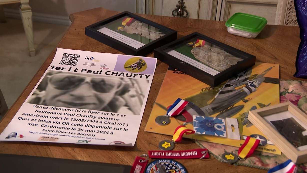 Heirlooms of the Saunders family after their trip to Normandy, including a poster advertising in French the ceremony that memorialized their relative, U.S. Army Air Force Pilot Paul Chaufty. Chaufty's plane crashed in the village of Saint Ellier Les Bois, in France.