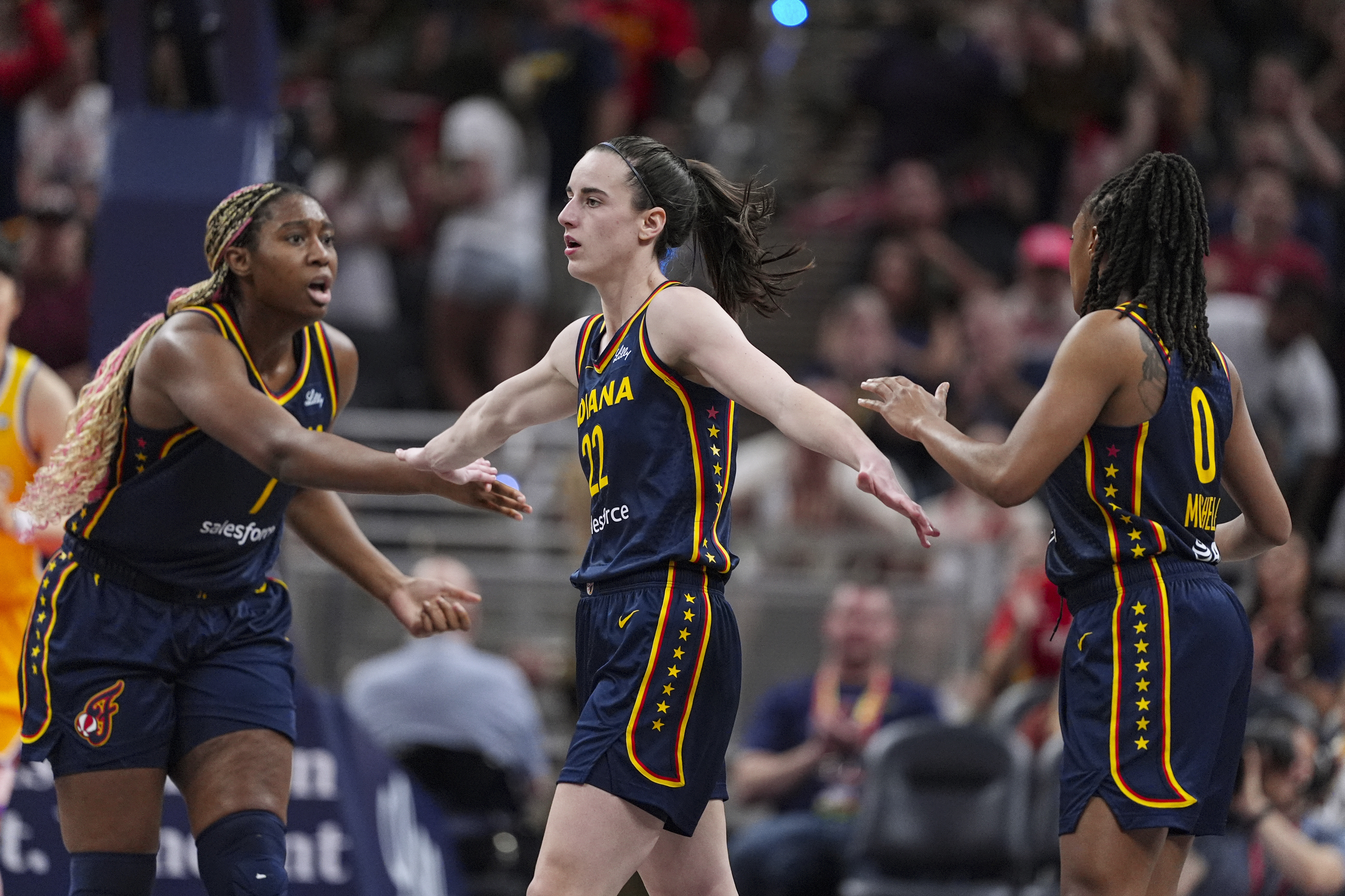 Indiana Fever guard Caitlin Clark (22) is congratulated by Aliyah Boston (7) and Kelsey Mitchell (0) during the second half of the team's WNBA basketball game against the Los Angeles Sparks in Indianapolis, Tuesday, May 28, 2024. 