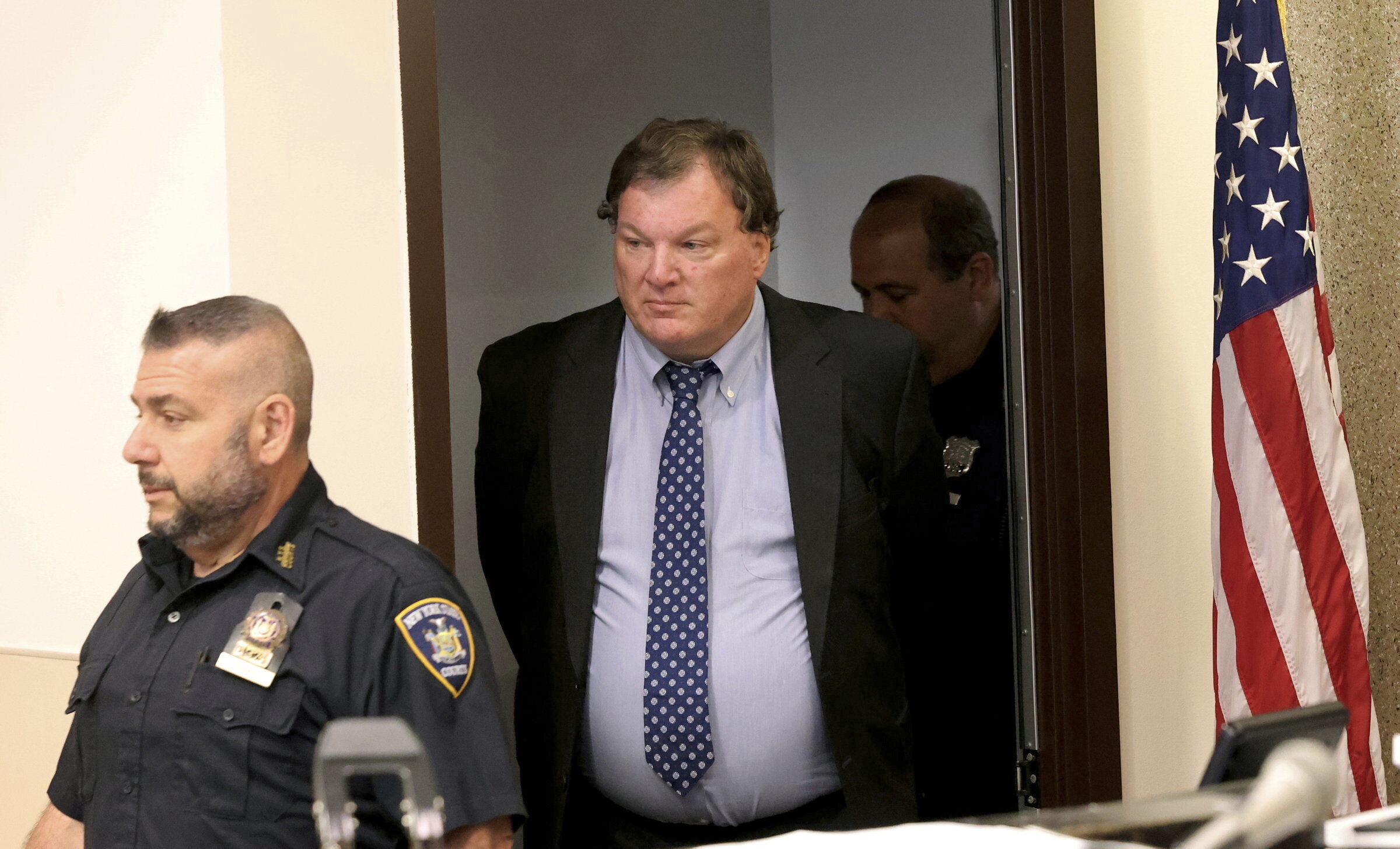 Rex Heuermann, center, charged in the Gilgo Beach serial killings on Long Island, enters the courtroom for a hearing at Suffolk County Court in Riverhead, N.Y., Thursday. Heuermann was charged Thursday in the deaths of two more women.