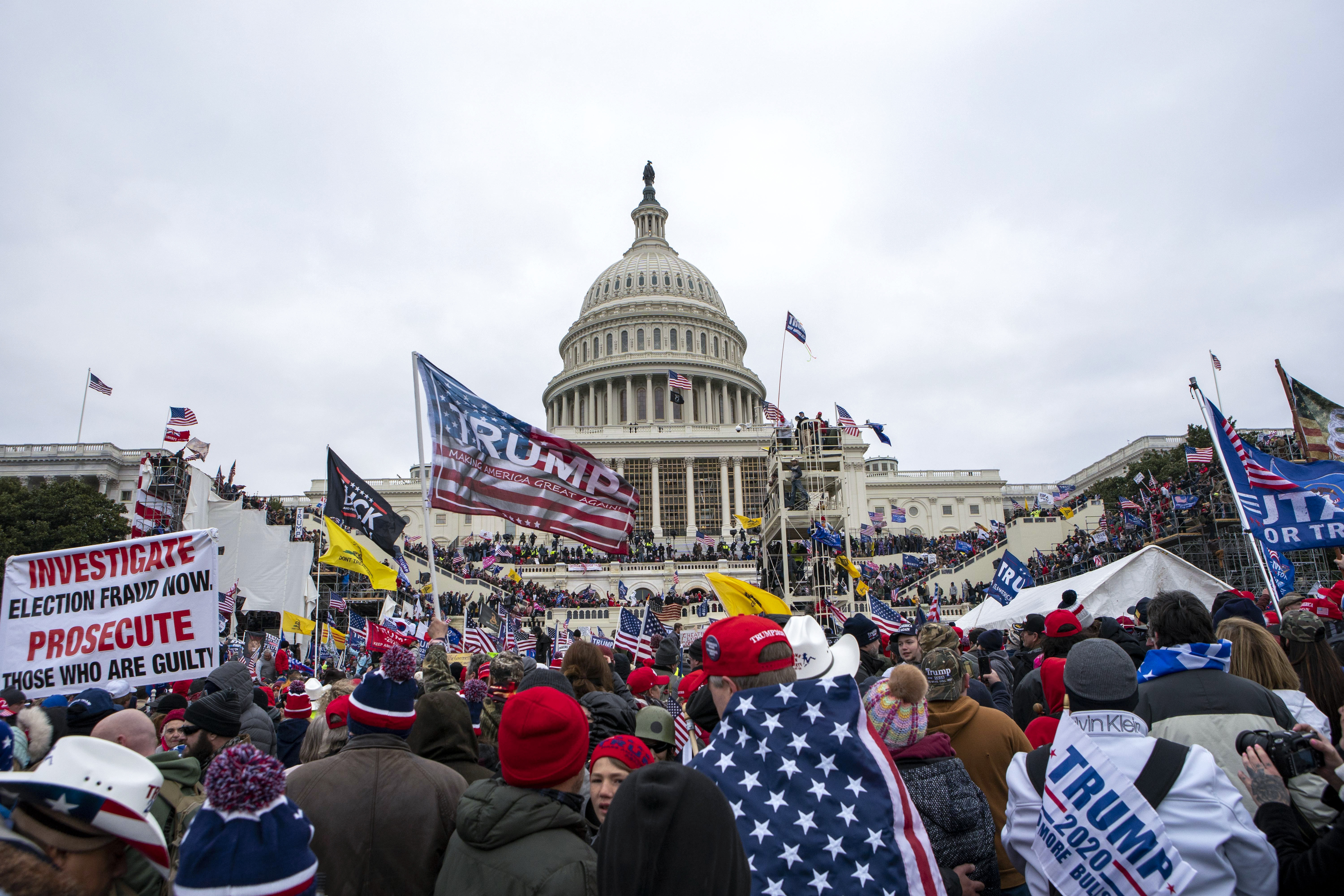 FILE - Rioters loyal to President Donald Trump rally at the U.S. Capitol in Washington, Jan. 6, 2021. Retired NASCAR driver Tighe Scott, his adult son and two other Pennsylvania men are facing felony charges stemming from confrontations with police during the Jan. 6, 2021, siege on the U.S. Capitol. 