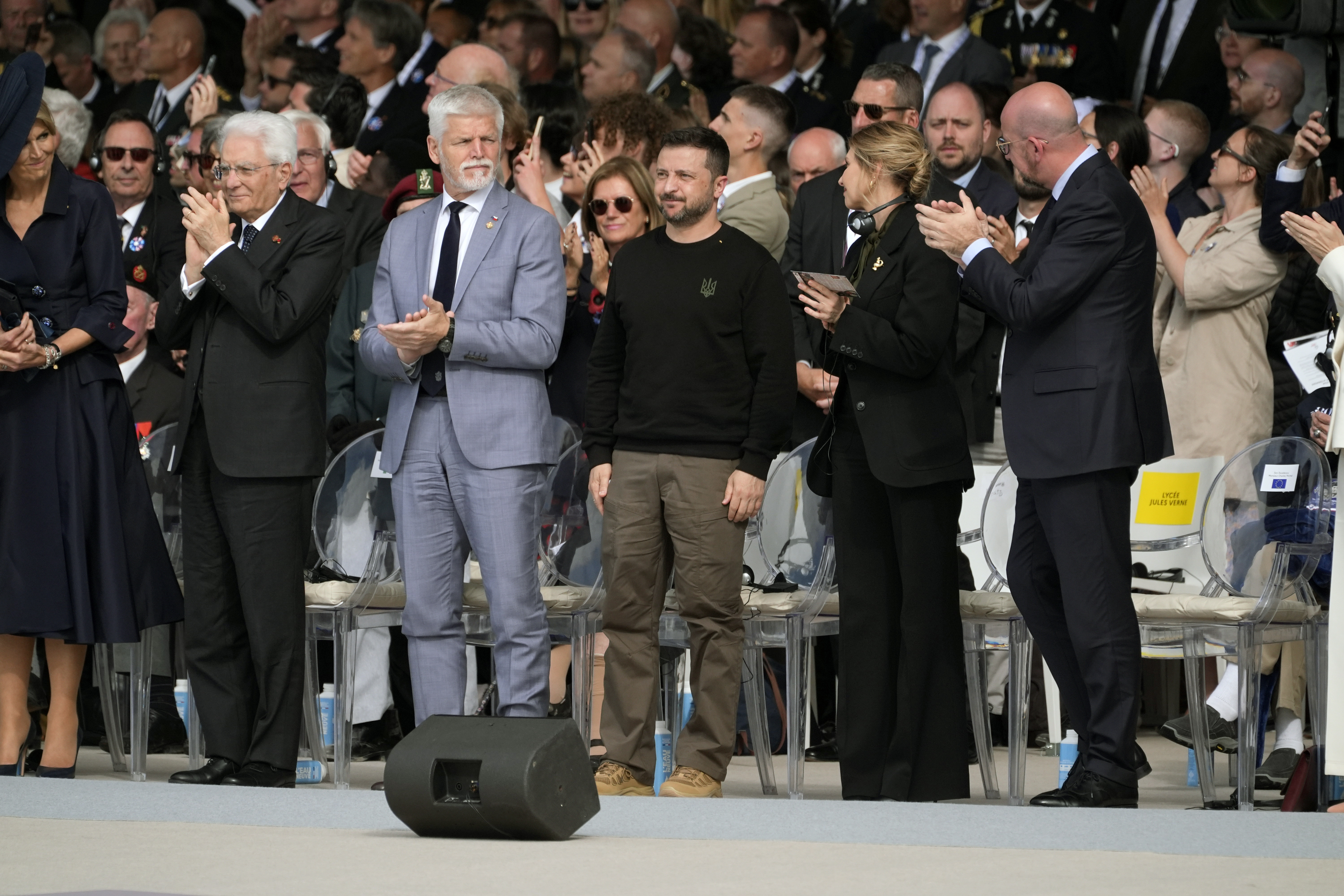 Ukraine President Volodymyr Zelenskyy, center, and other dignitaries, attend an international ceremony to mark the 80th anniversary of D-Day, Thursday, in Normandy. President Joe Biden apologizes to Zelenskyy for holdup on military assistance.