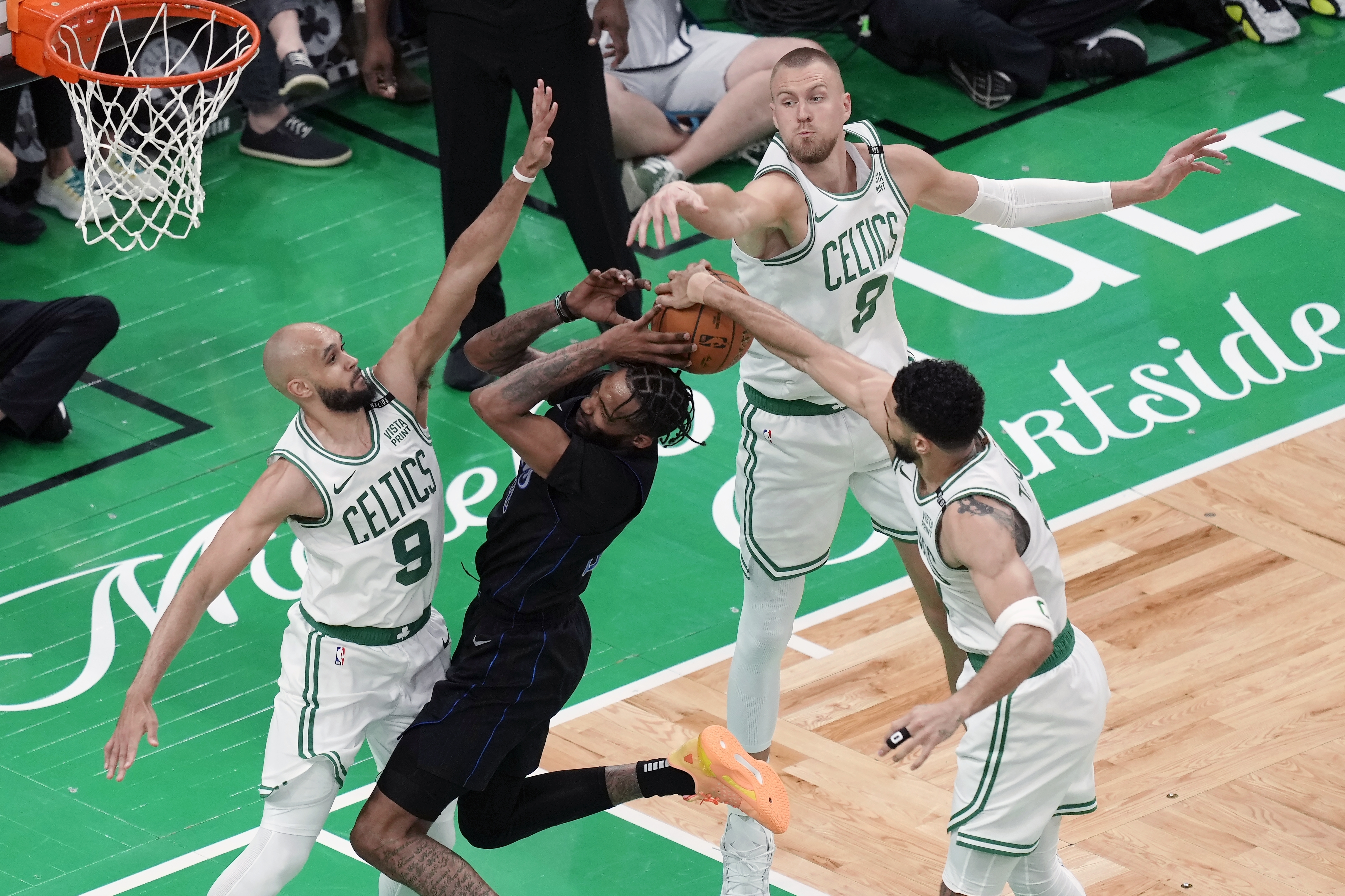 Boston Celtics' Derrick White (9), Kristaps Porzingis (8) and Jayson Tatum (0) block a shot by Dallas Mavericks' Derrick Jones Jr. (55) during the second half of Game 1 of basketball's NBA Finals on Thursday, June 6, 2024, in Boston.