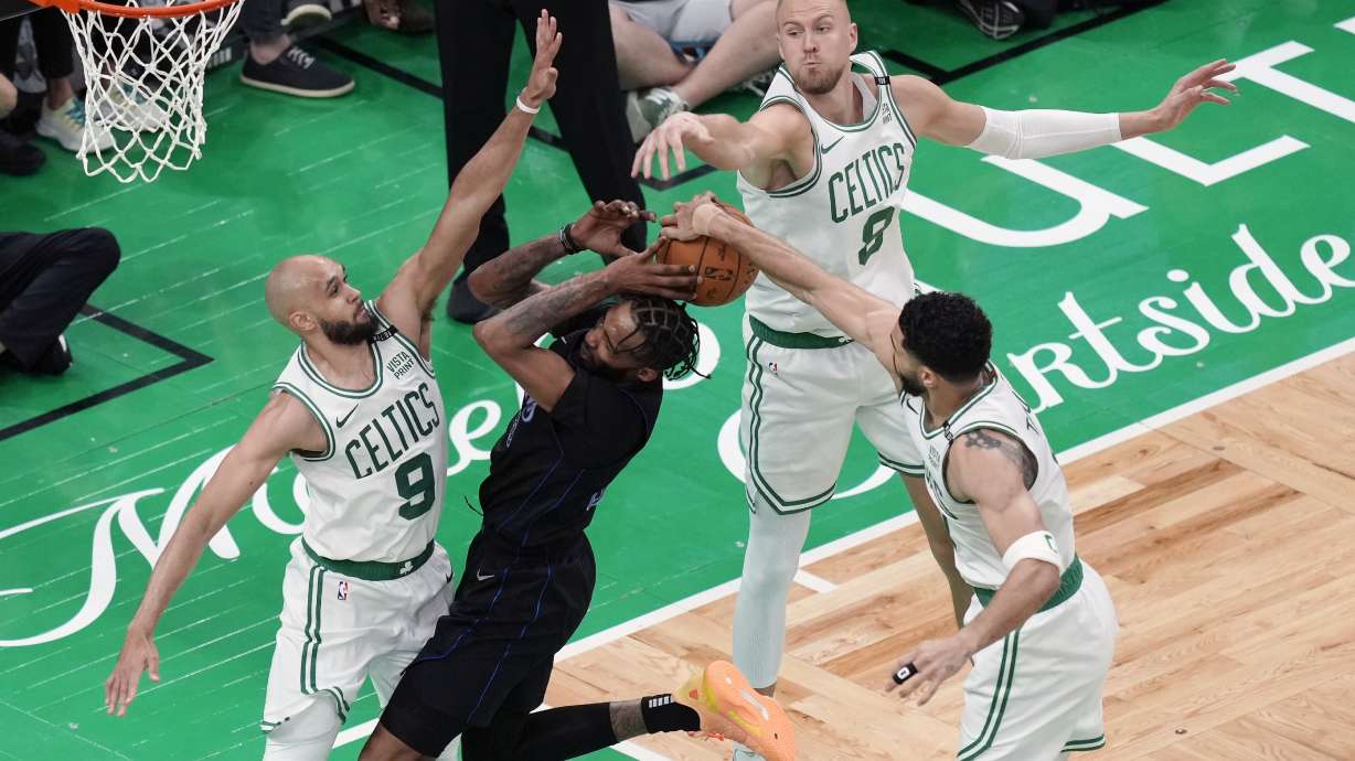 Boston Celtics' Derrick White (9), Kristaps Porzingis (8) and Jayson Tatum (0) block a shot by Dallas Mavericks' Derrick Jones Jr. (55) during the second half of Game 1 of basketball's NBA Finals on Thursday, June 6, 2024, in Boston.