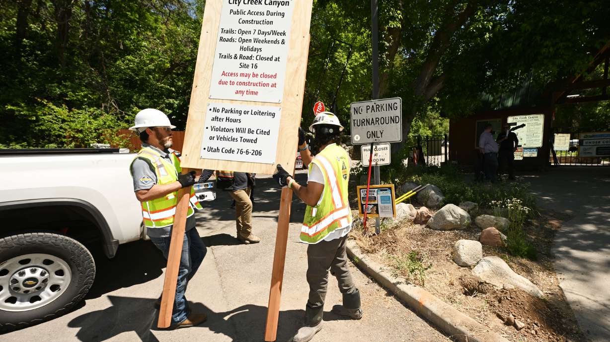 Workers install a sign after Salt Lake City Department of Public Utilities held a news conference highlighting public safety concerns related to increased pedestrian and cyclist traffic in closed areas of City Creek Canyon on Friday.