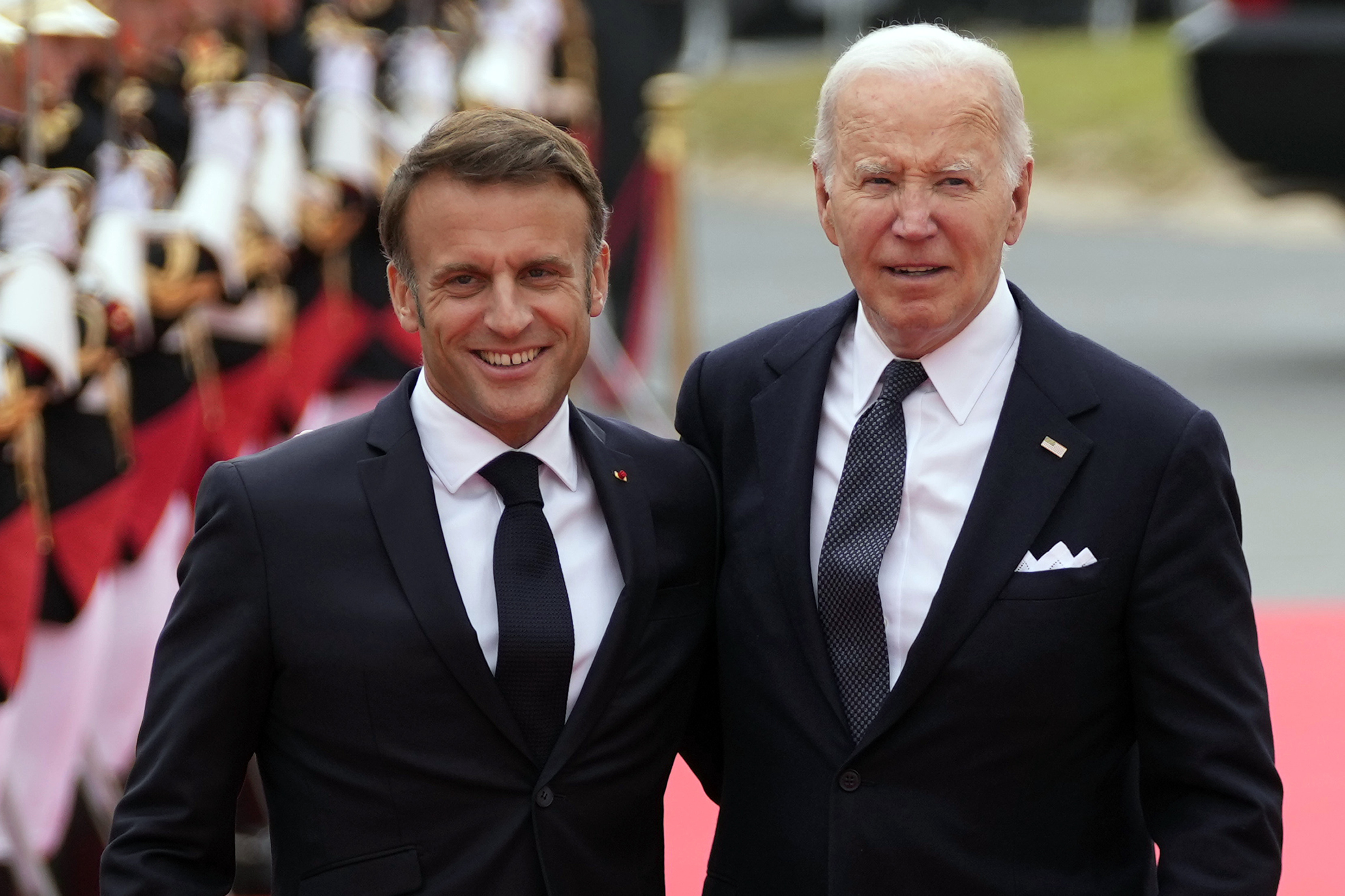 President Joe Biden, right, and French President Emmanuel Macron arrive at the international ceremony at Omaha Beach Thursday in Normandy, France. Biden is being feted with a state visit this weekend by Macron in Paris.