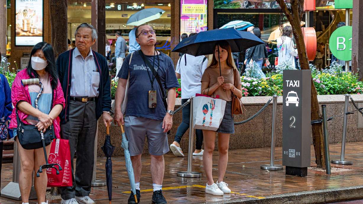 People wait for taxis in Hong Kong, China, on May 24. Uber remains technically illegal in Hong Kong, which it entered in 2014. But it has thrived under the ambiguous approach of officials keen to project an image of technological modernity.