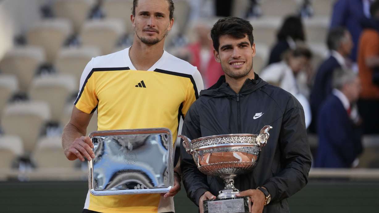 Winner Spain's Carlos Alcaraz, right, and second placed Germany's Alexander Zverev pose with their trophies after the men's final match of the French Open tennis tournament at the Roland Garros stadium in Paris, Sunday, June 9, 2024.