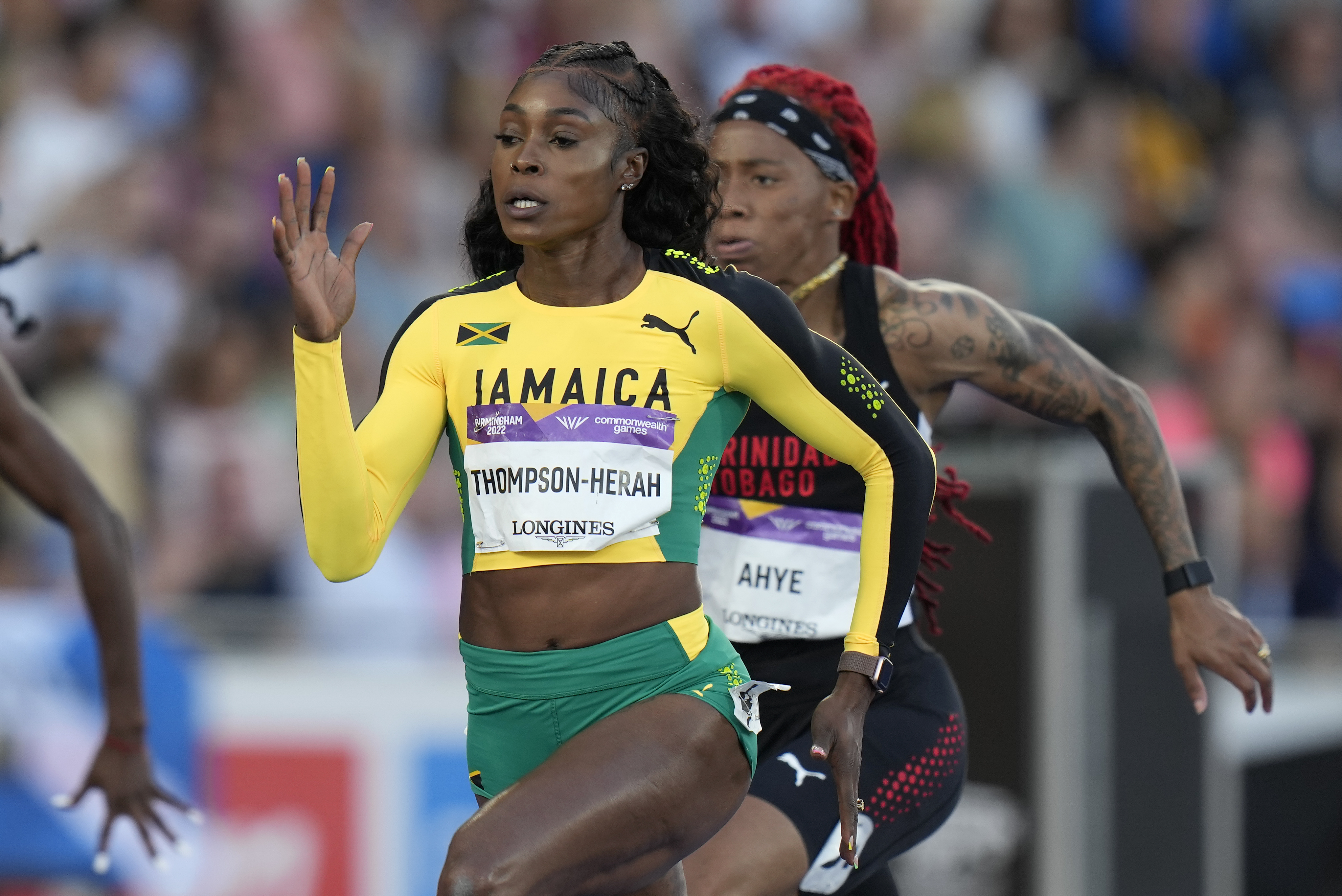 FILE - Jamaica's Elaine Thompson-Herah, center, races to win a women's 100m semifinal during the athletics in the Alexander Stadium at the Commonwealth Games in Birmingham, England, Wednesday, Aug. 3, 2022. Is trying to join Usain Bolt as only the second person to win three straight gold medals at both 100 and 200 meters. 