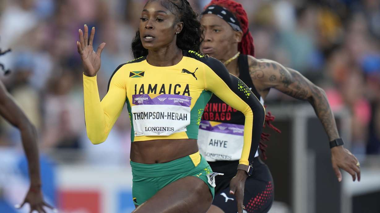FILE - Jamaica's Elaine Thompson-Herah, center, races to win a women's 100m semifinal during the athletics in the Alexander Stadium at the Commonwealth Games in Birmingham, England, Wednesday, Aug. 3, 2022. Is trying to join Usain Bolt as only the second person to win three straight gold medals at both 100 and 200 meters.