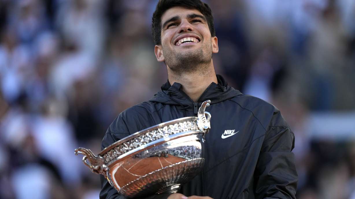 Winner Spain's Carlos Alcaraz celebrates with the trophy as he won the men's final match of the French Open tennis tournament against Germany's Alexander Zverev at the Roland Garros stadium in Paris, Sunday, June 9, 2024.
