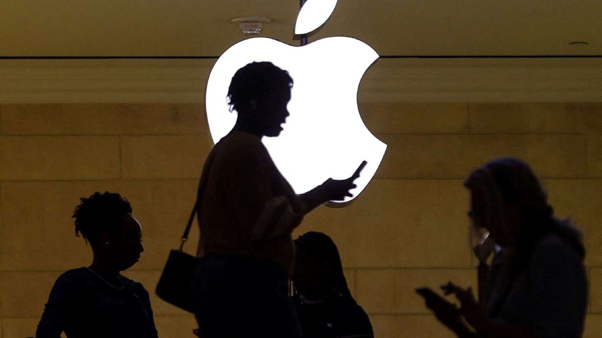A woman uses an iPhone at the Apple store at Grand Central Terminal in New York City. Apple and the union representing retail workers at its store in Towson, Maryland, agreed to a tentative labor deal late Friday.